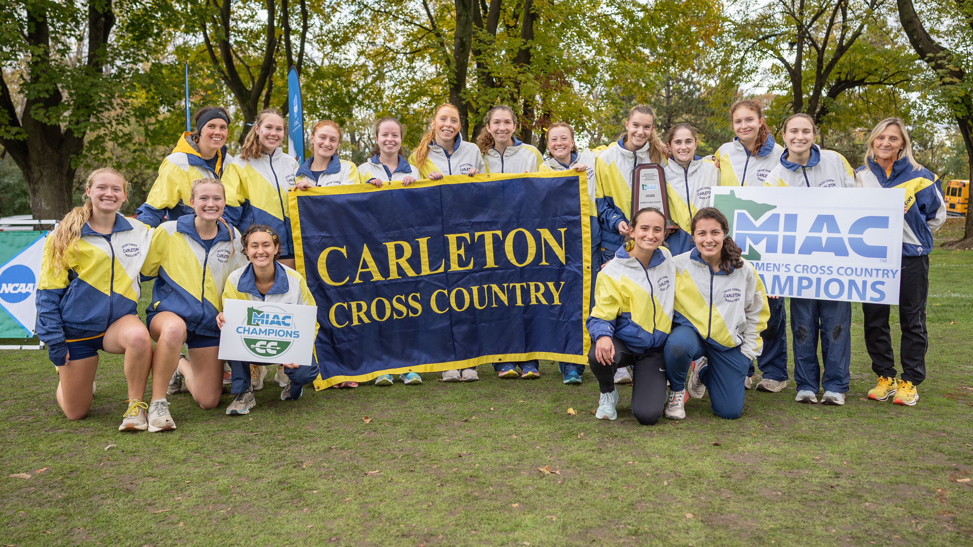 Carleton women's cross country holding MIAC Championship signs