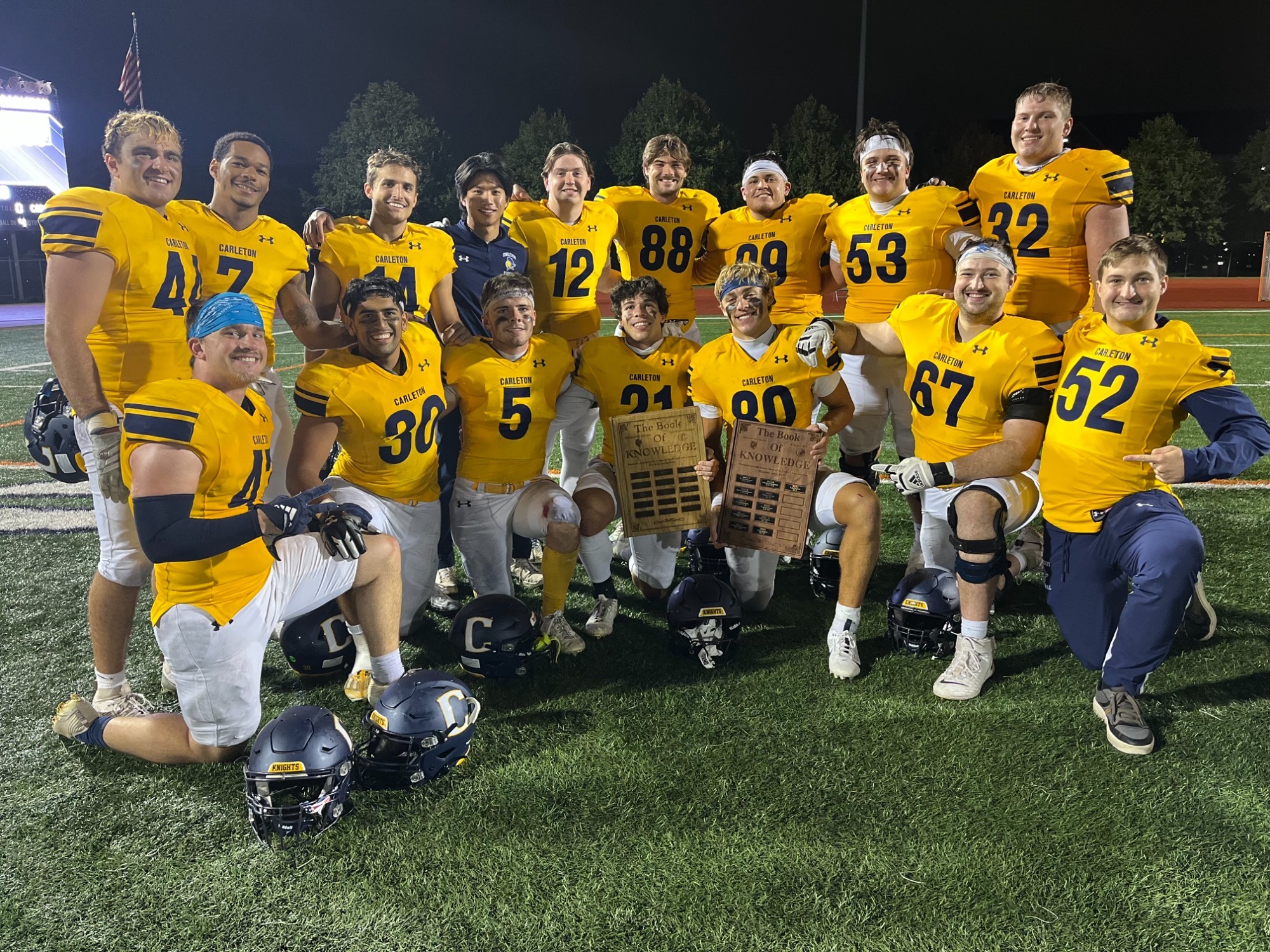 The Carleton football seniors pose with the Book of Knowledge trophy