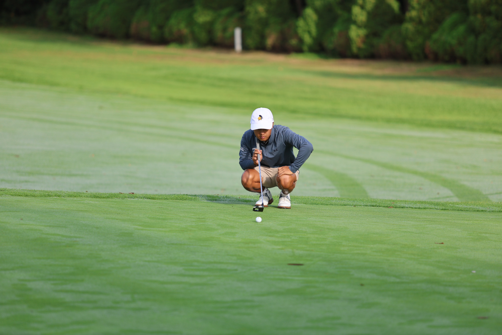 Sam Higaki lining up a putt