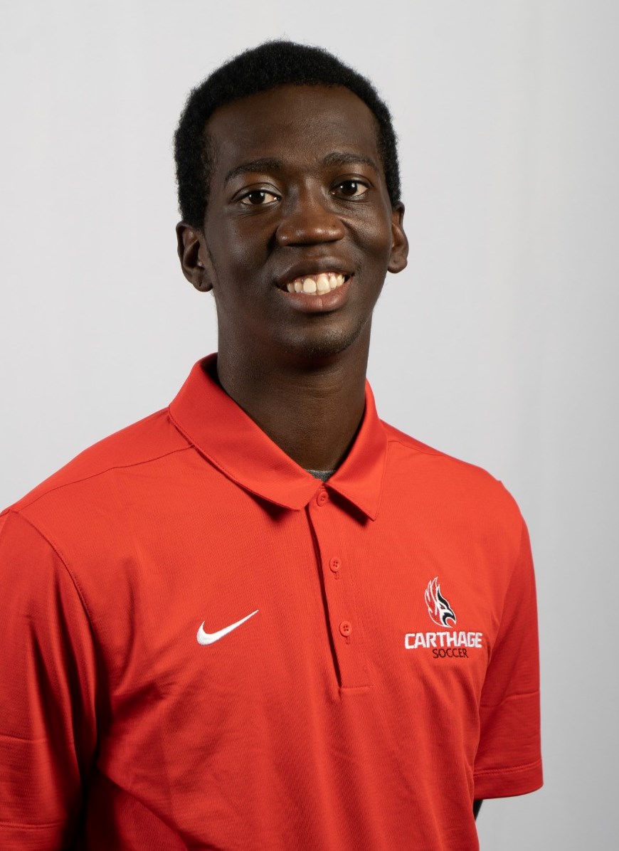 Cale Brown smiling for their men's soccer headshot, wearing a red Firebirds polo. 