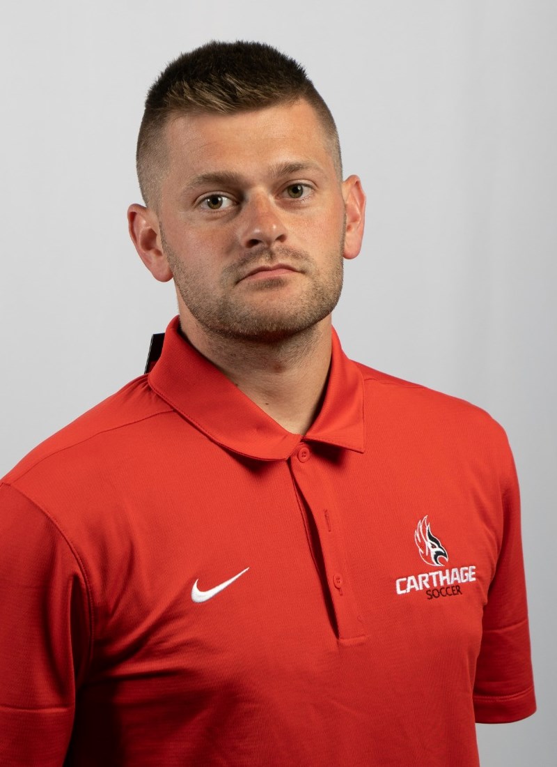 Colton Walter smiling for their men's soccer headshot, wearing a red Firebirds polo. 