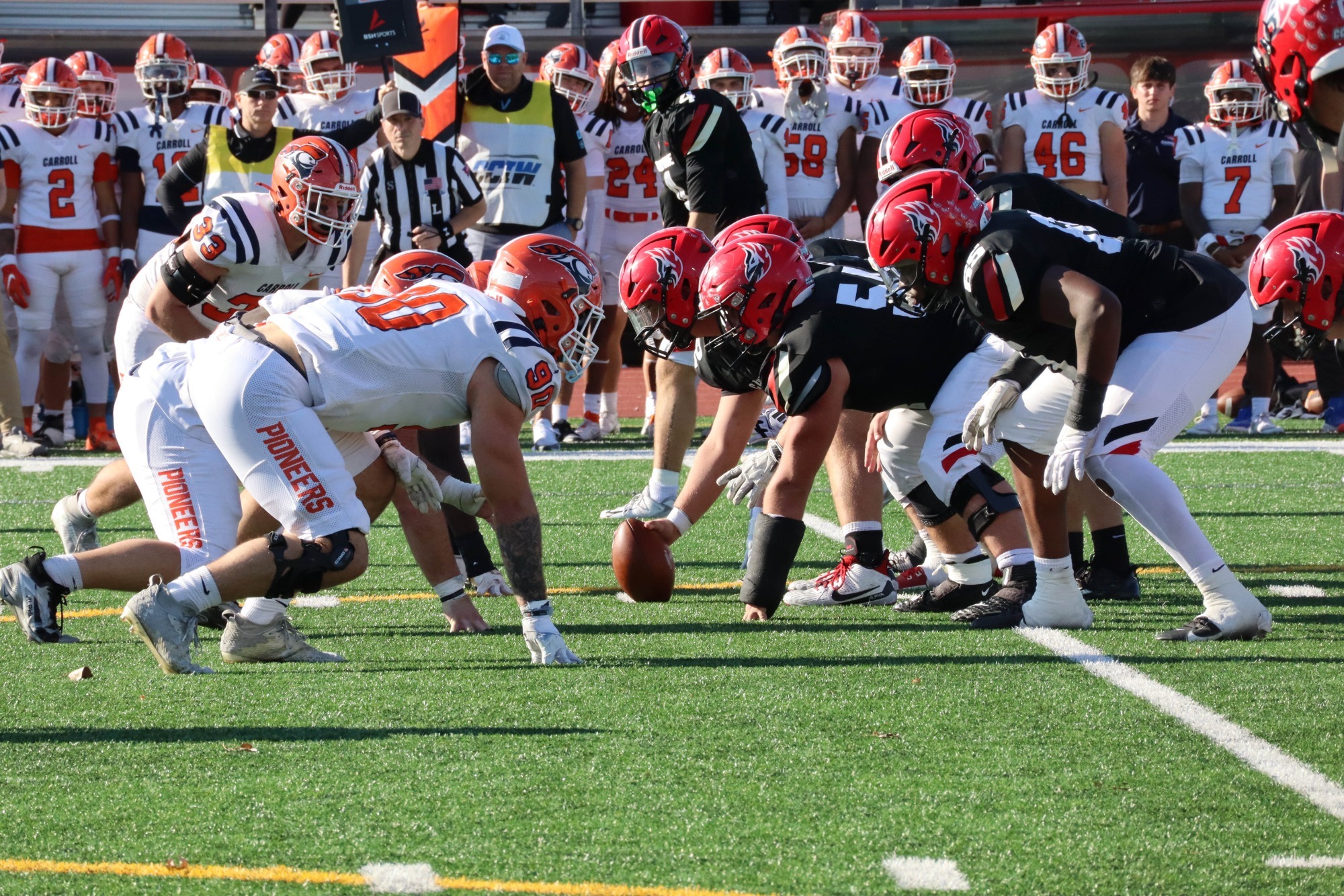 Football players prepare for the snap