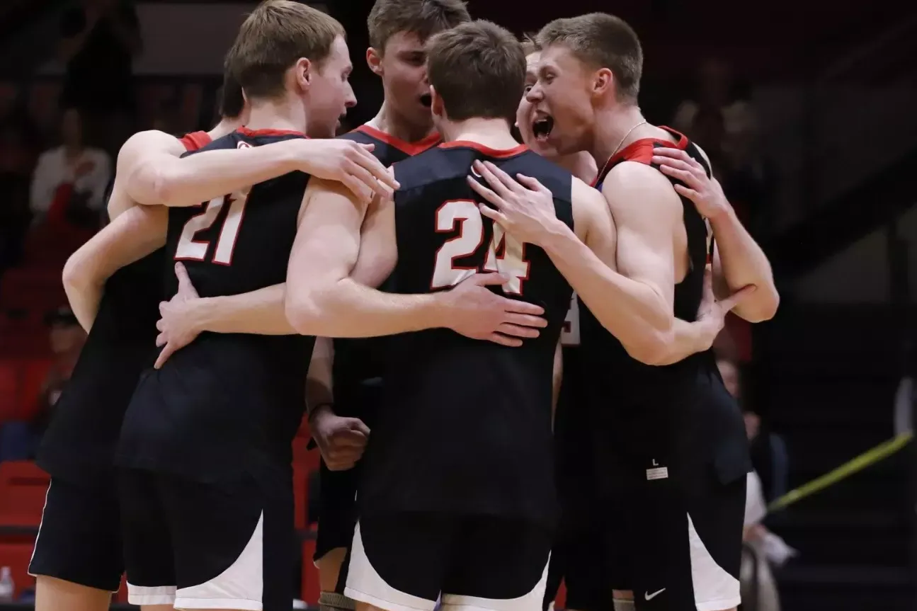 Men's volleyball gathers after a point against Springfield