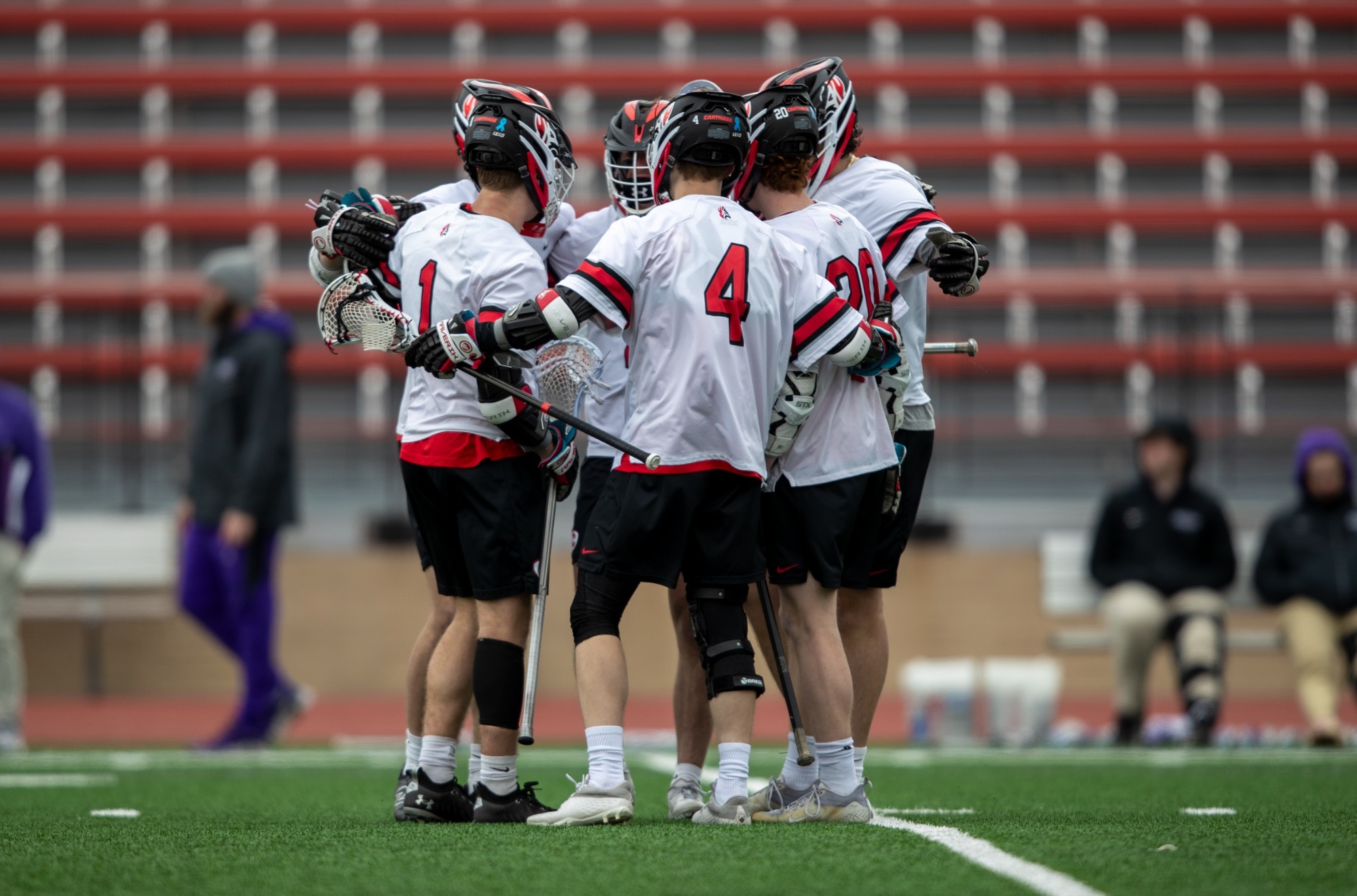 Men's lacrosse gathers in a huddle 