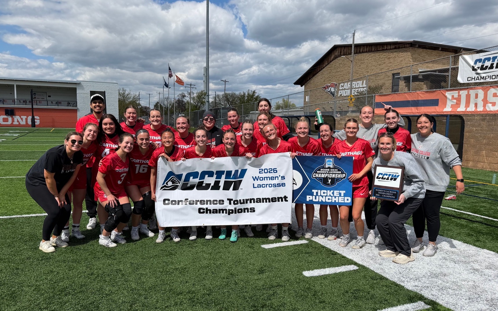 Women's lacrosse team poses with their CCIW Tournament plaque
