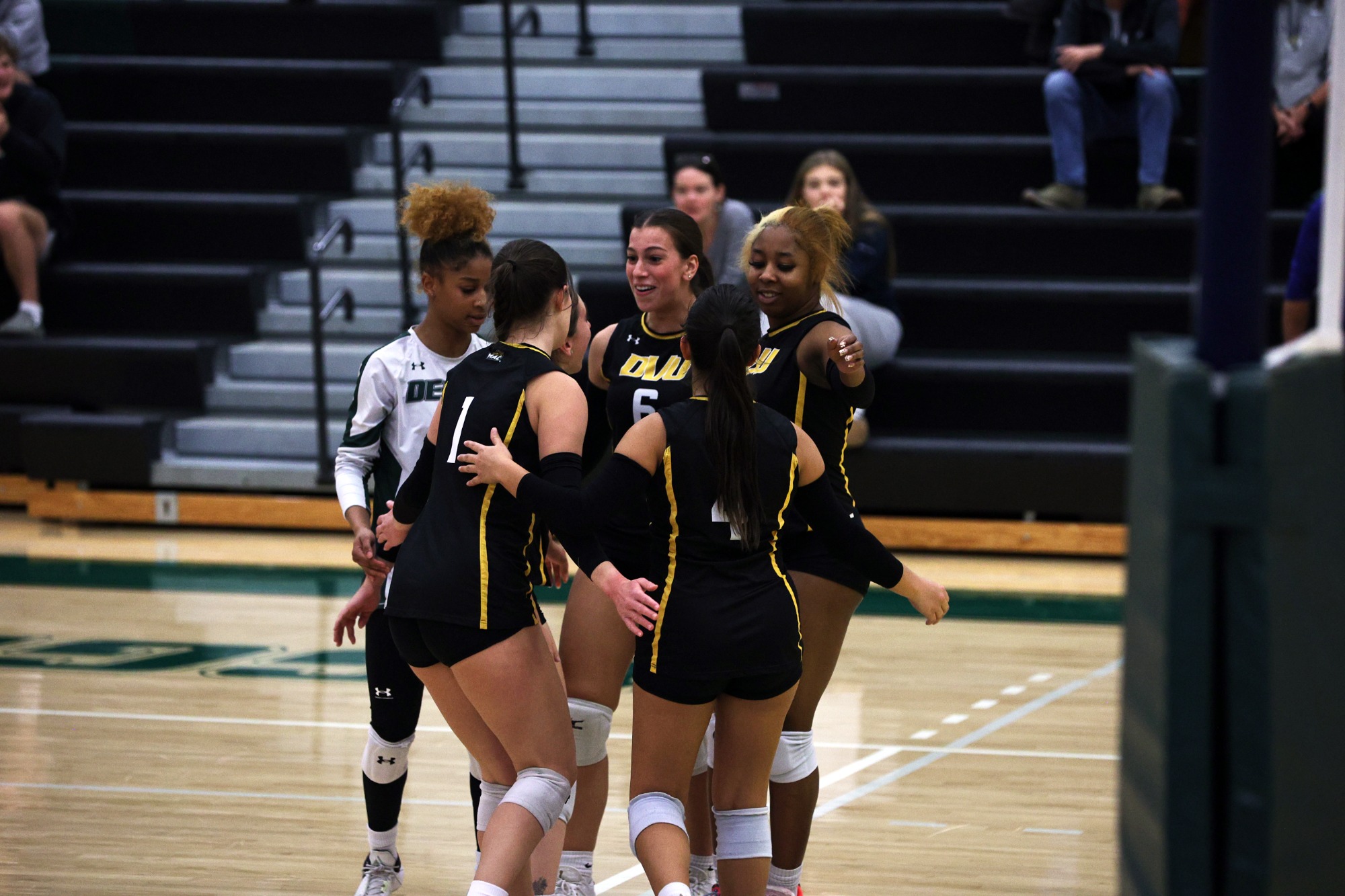 Women's volleyball on court celebration huddle in game vs. Lebanon Valley 
