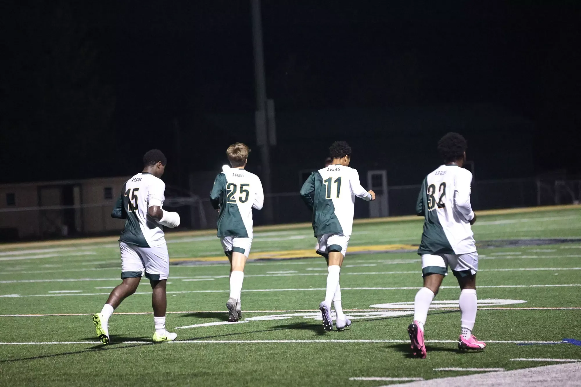 Men's soccer players running downfield vs. Saint Elizabeth