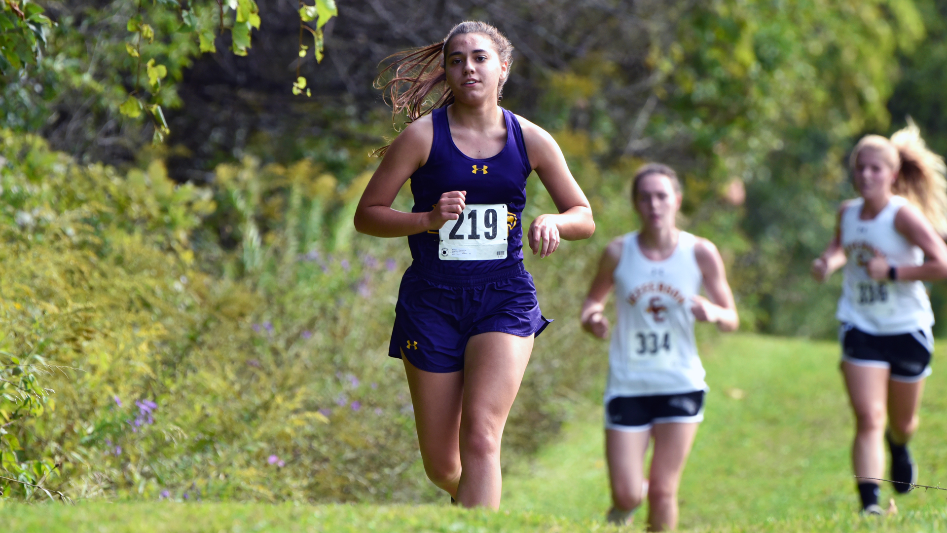 Danielle Knapp leads two opposing runners down a stretch at the 2019 Cazenovia Homecoming Invitational race