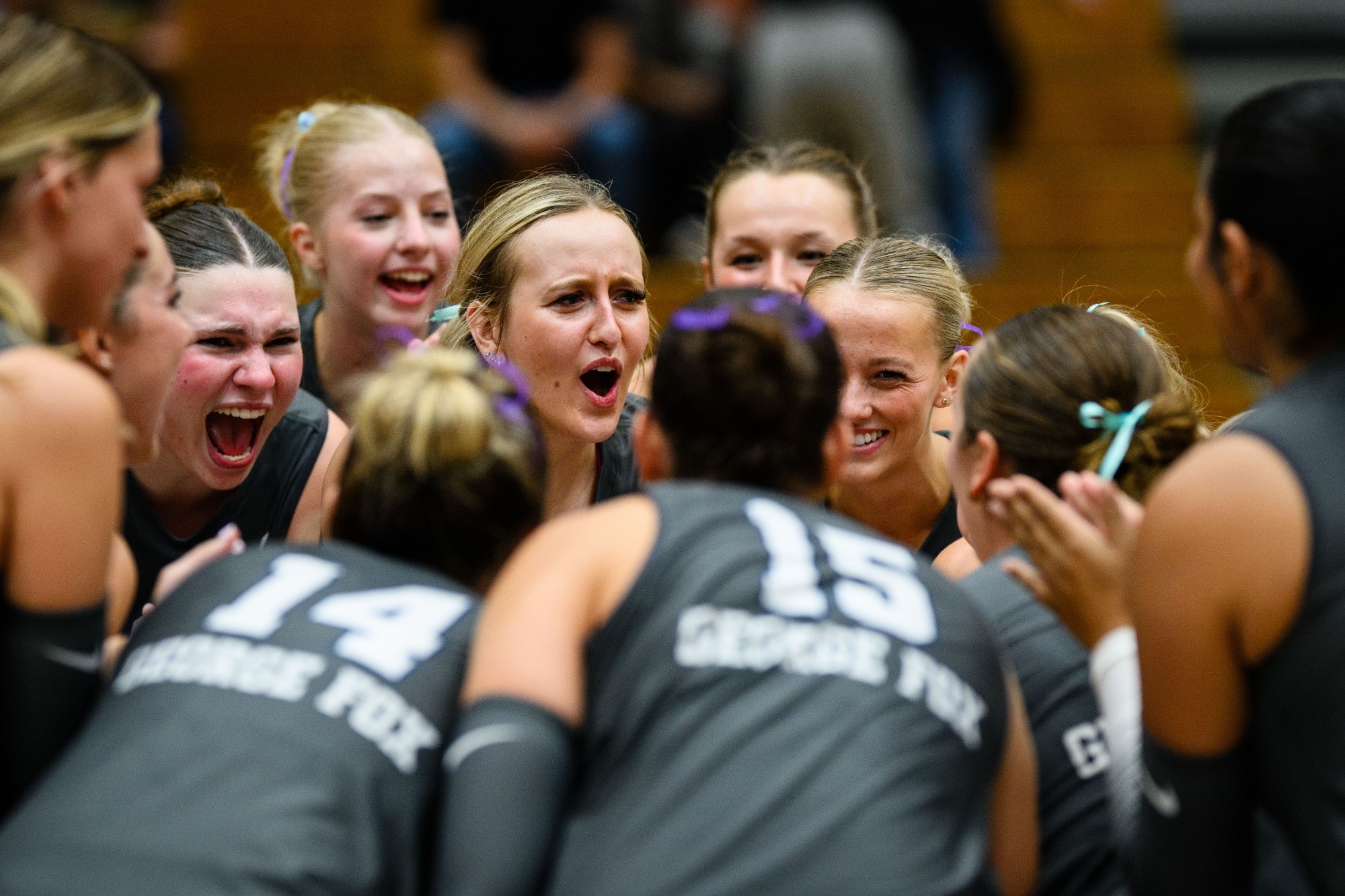 group of volleyball players together in huddle
