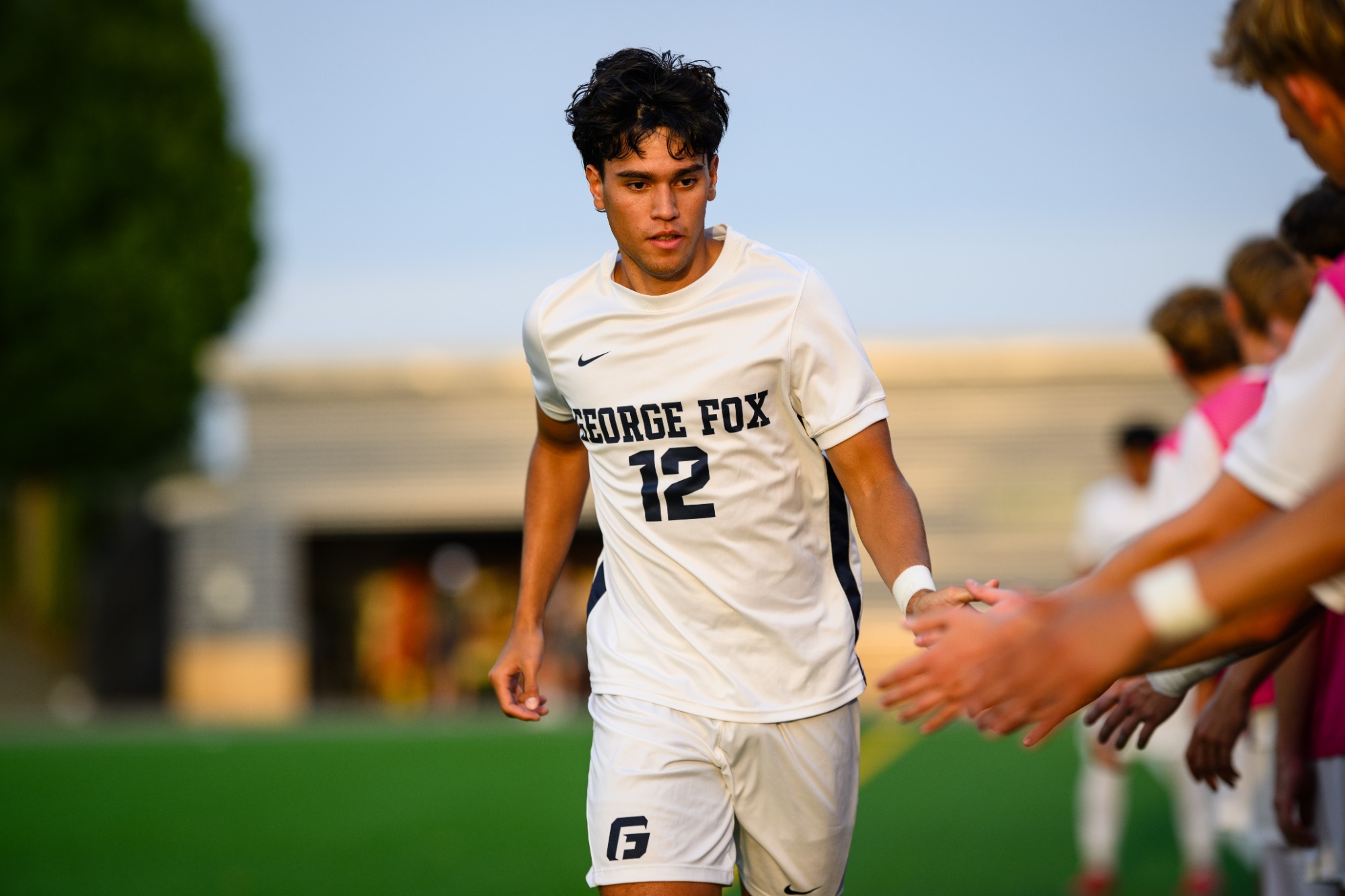 Elijah Soon running in high five line before game