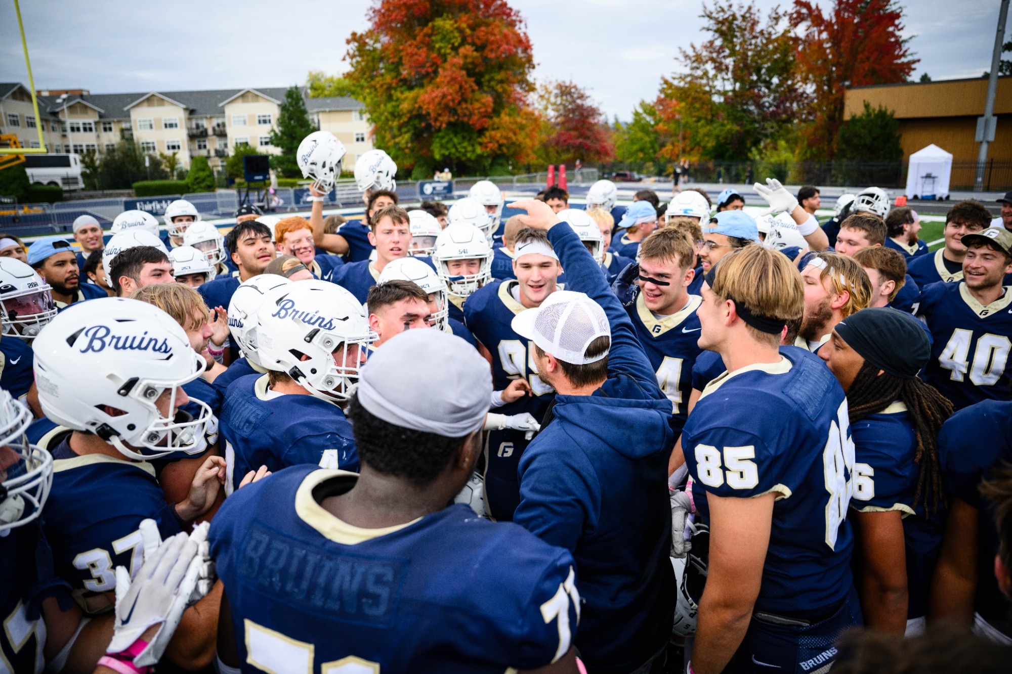 Group of animated George Fox players together in huddle 