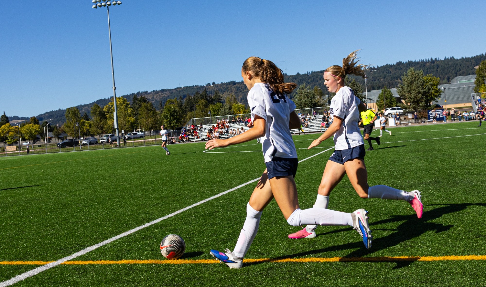 Addison Wolff and Mia Kalina next to each other with ball on field