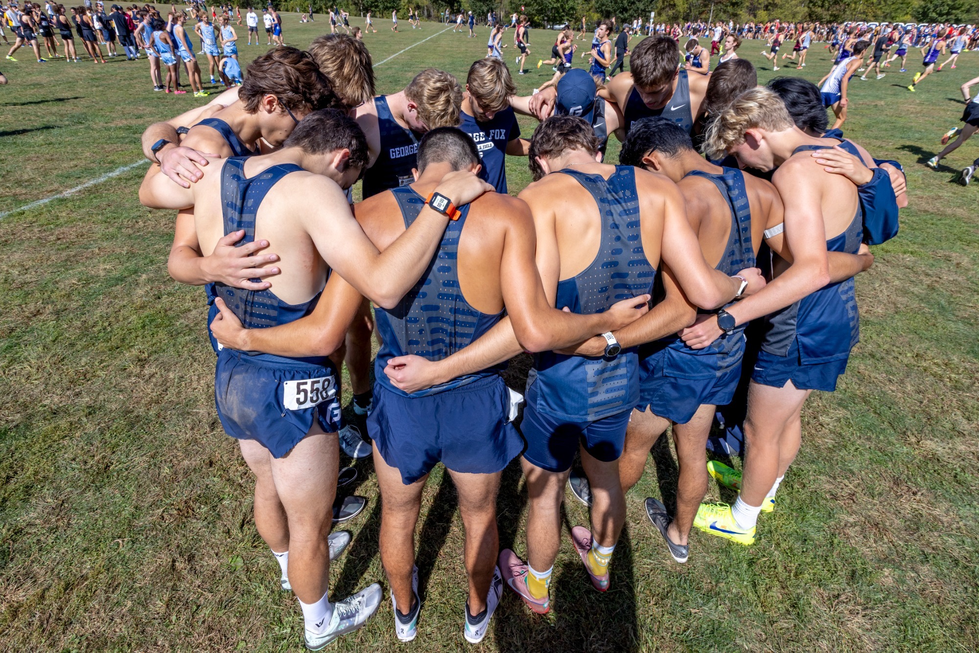 GFU men's cross country athletes huddled together 
