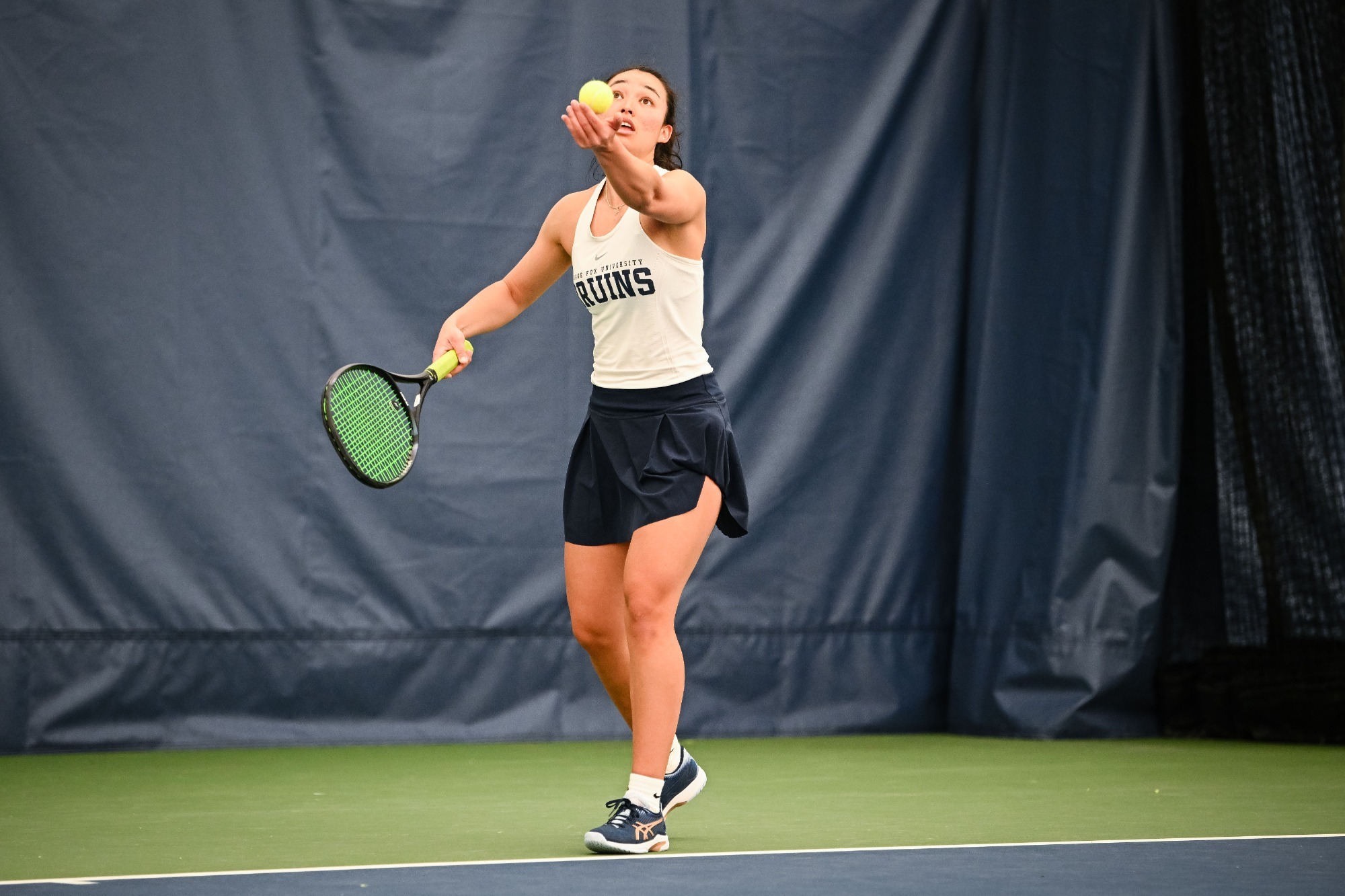 Kylie Hull about to lift ball for serve in air.
