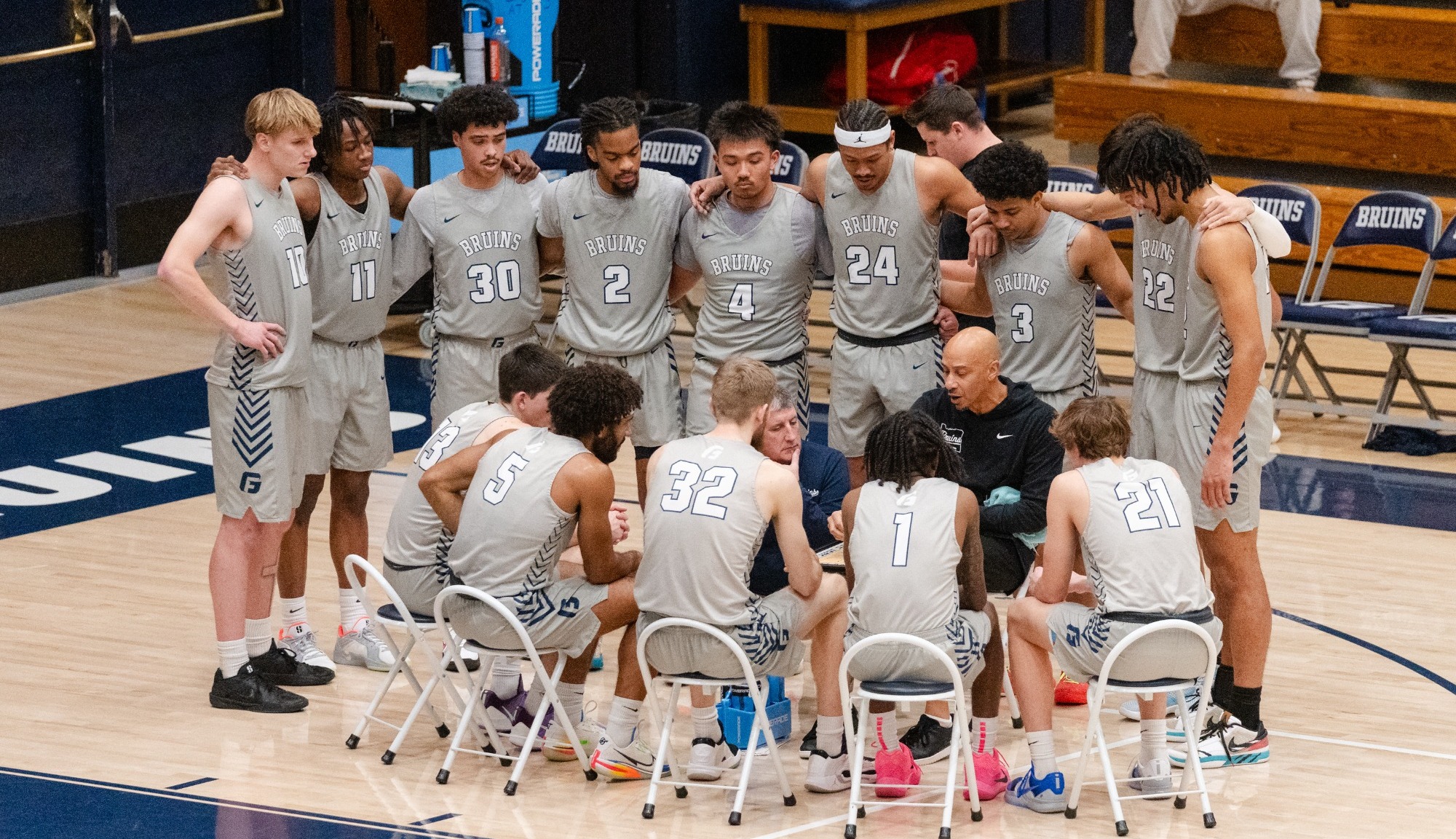 Men's basketball team in huddle during timeout