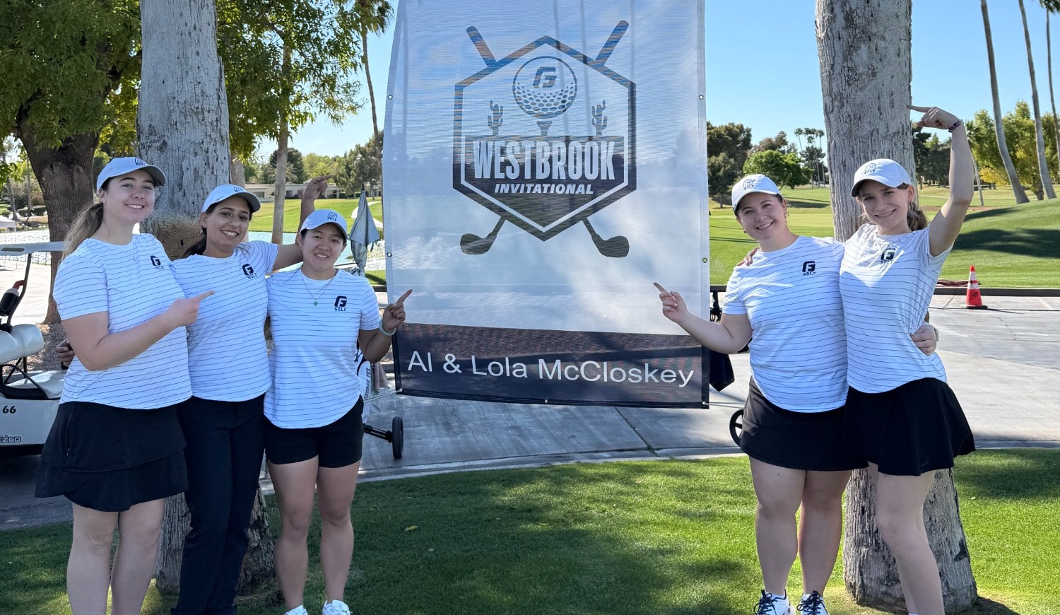 Bruins stand in front of a Westbrook Invite sign