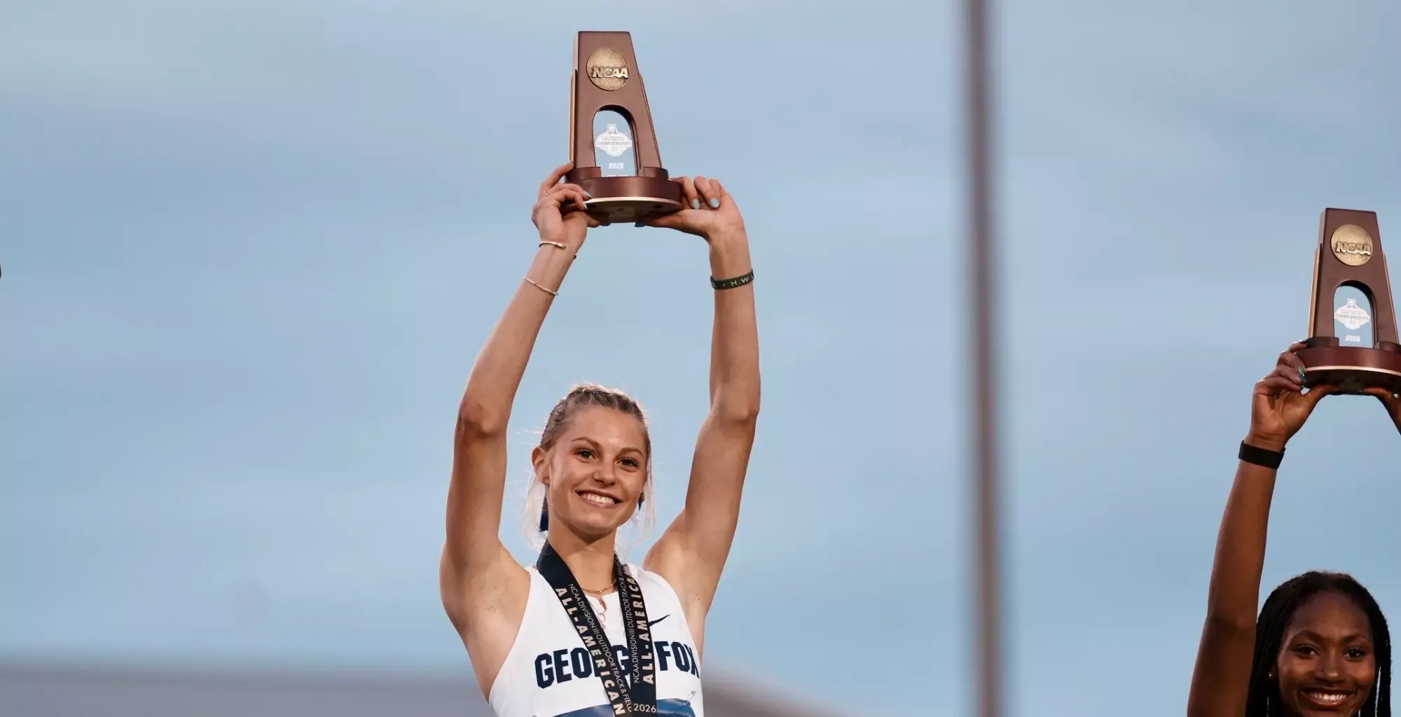 Janice Hellesto holding All-American trophy