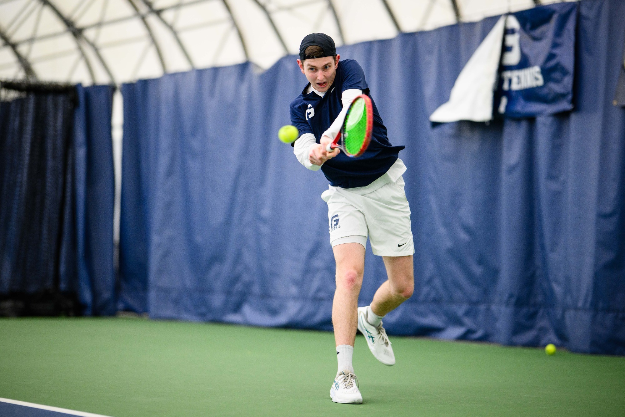 Zach Moore swings racket at ball