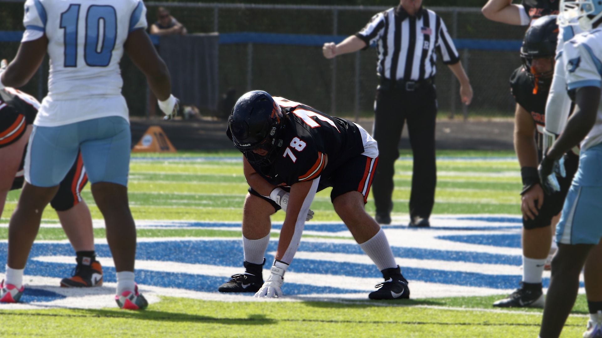 #78 in black jersey lining up for a tackle on the offensive line