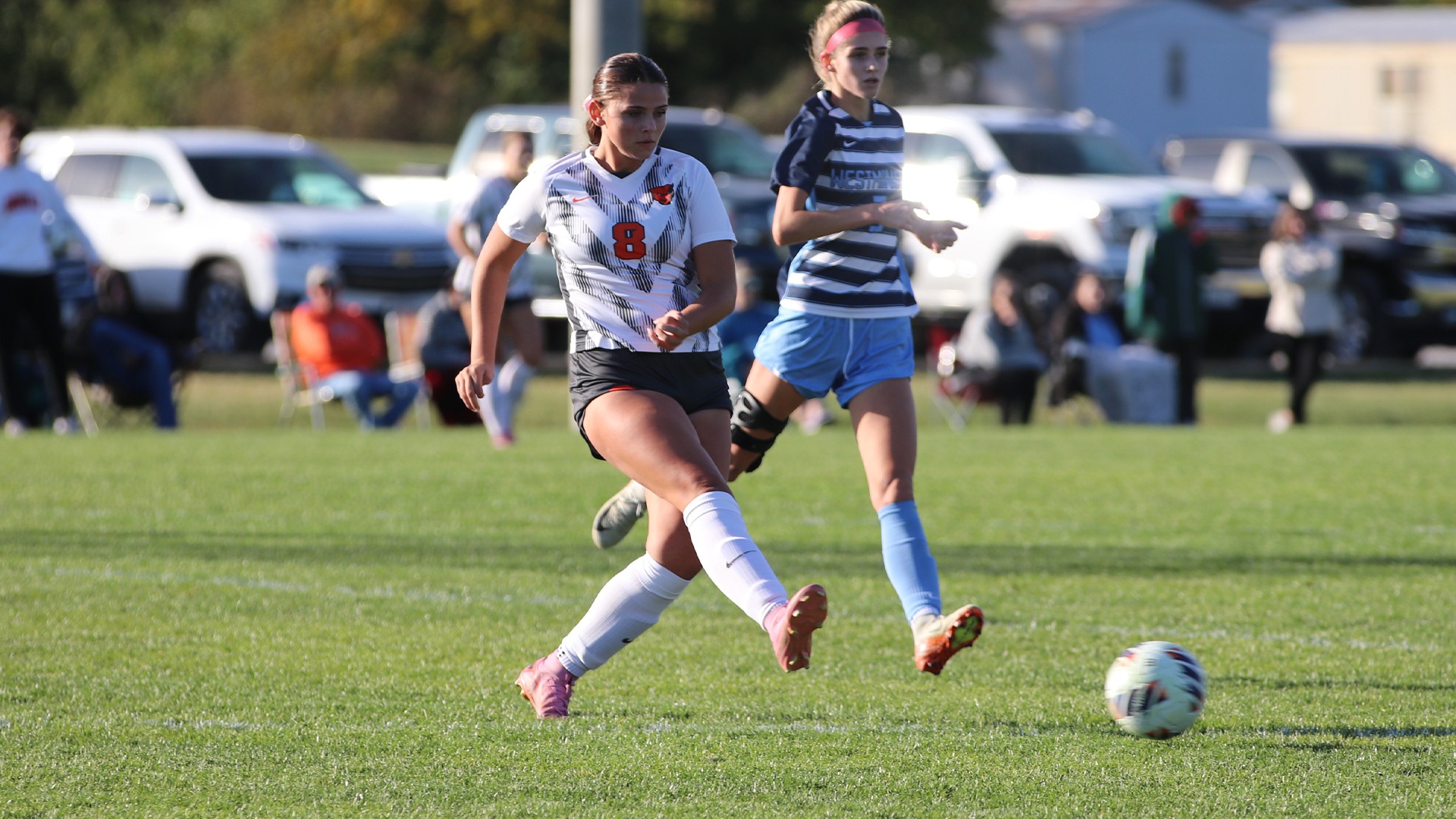 Brady Unger in white jersey kicking ball