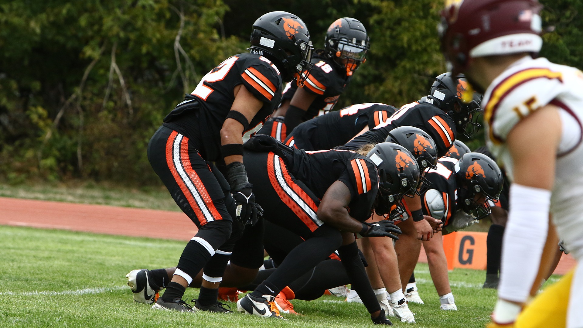 Greenville players in black jerseys lining up for snap 