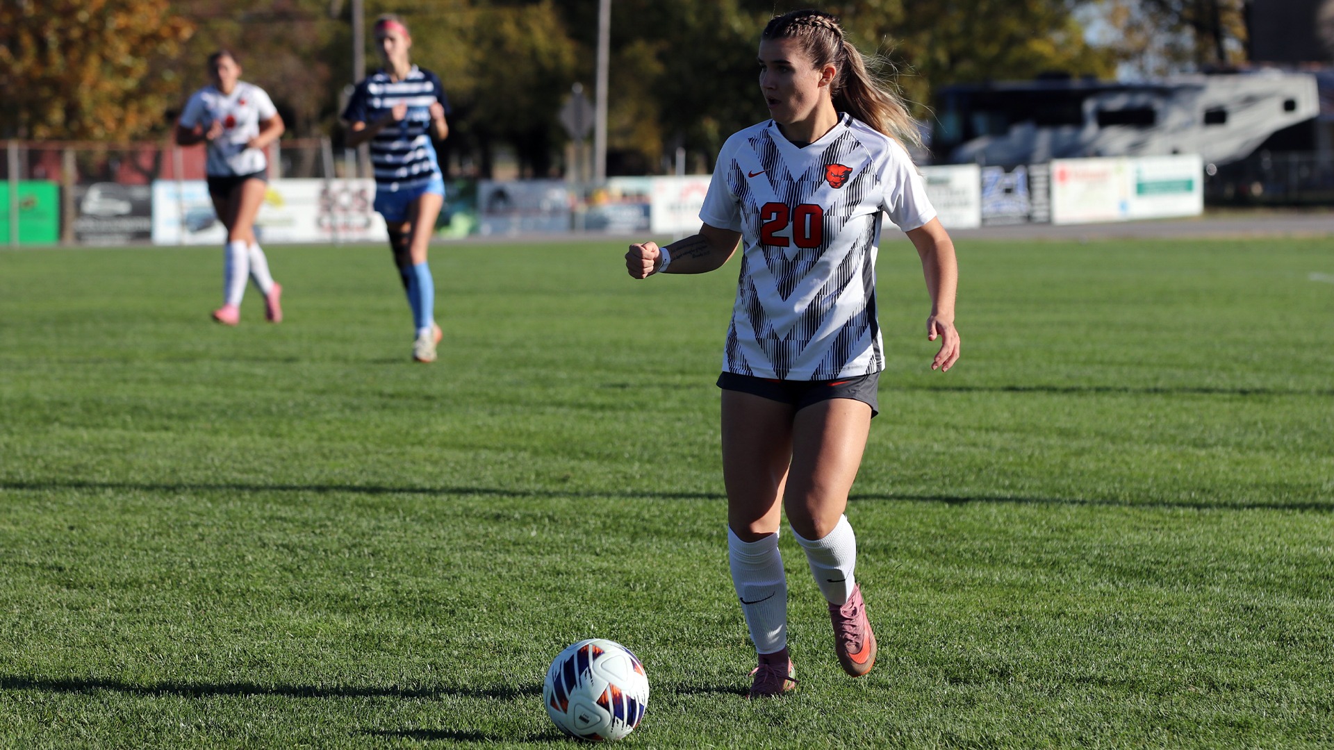 Katelyn Christensen in white jersey dribbling ball