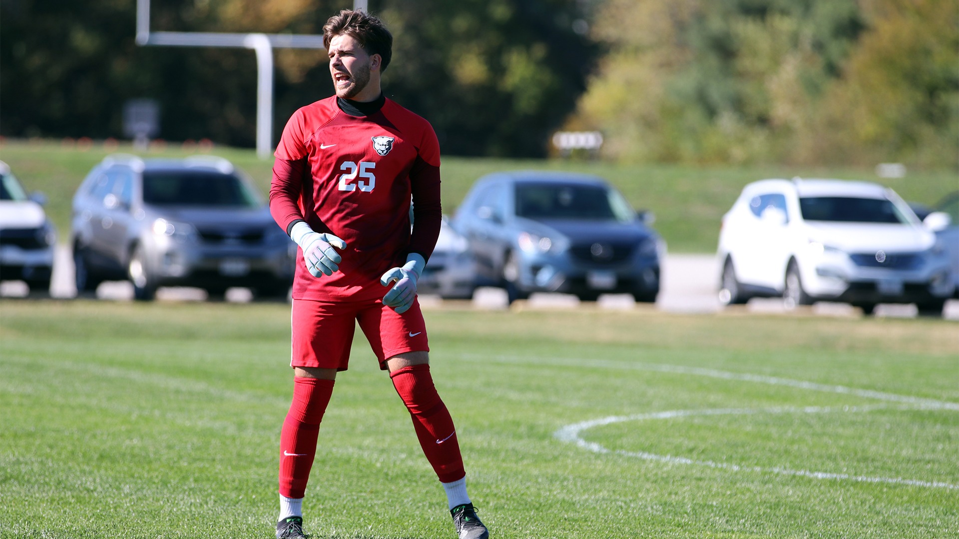 Tian Poyo in red goalie jersey yelling on field