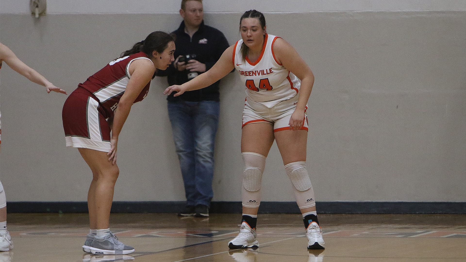 Alyssa Seymour in white jersey with right arm extended playing defense