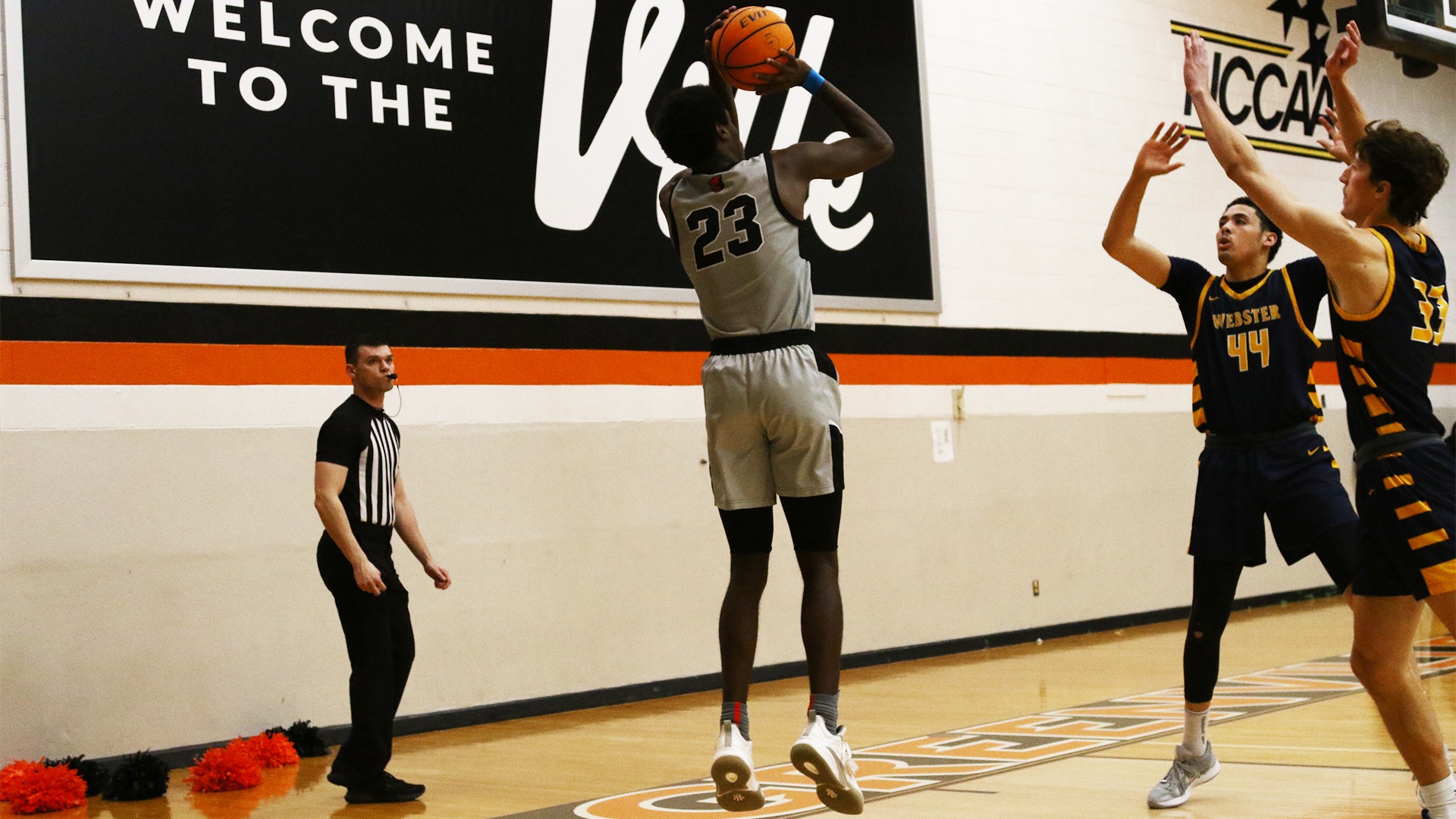 Comeaux in grey jersey shooting a three