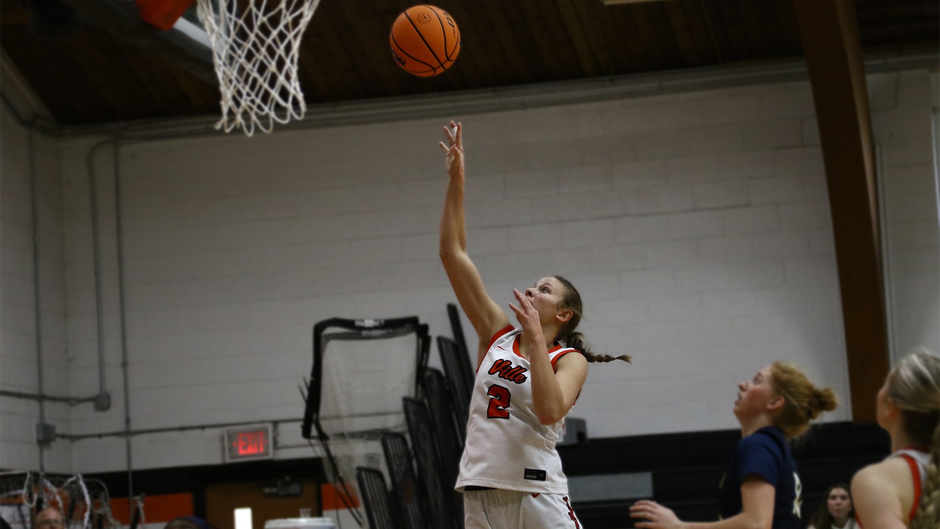 courtney brummer in white jersey laying the ball up