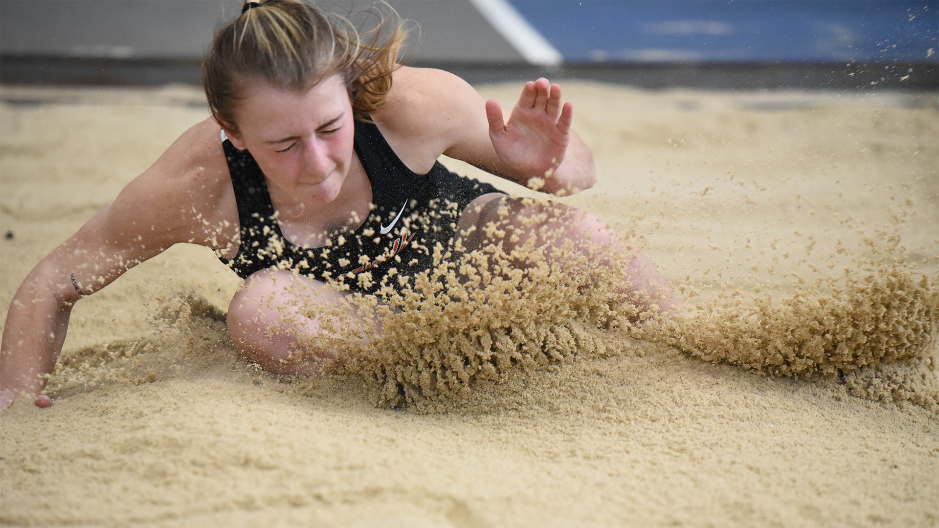 Woman Panther jumping into sand pit