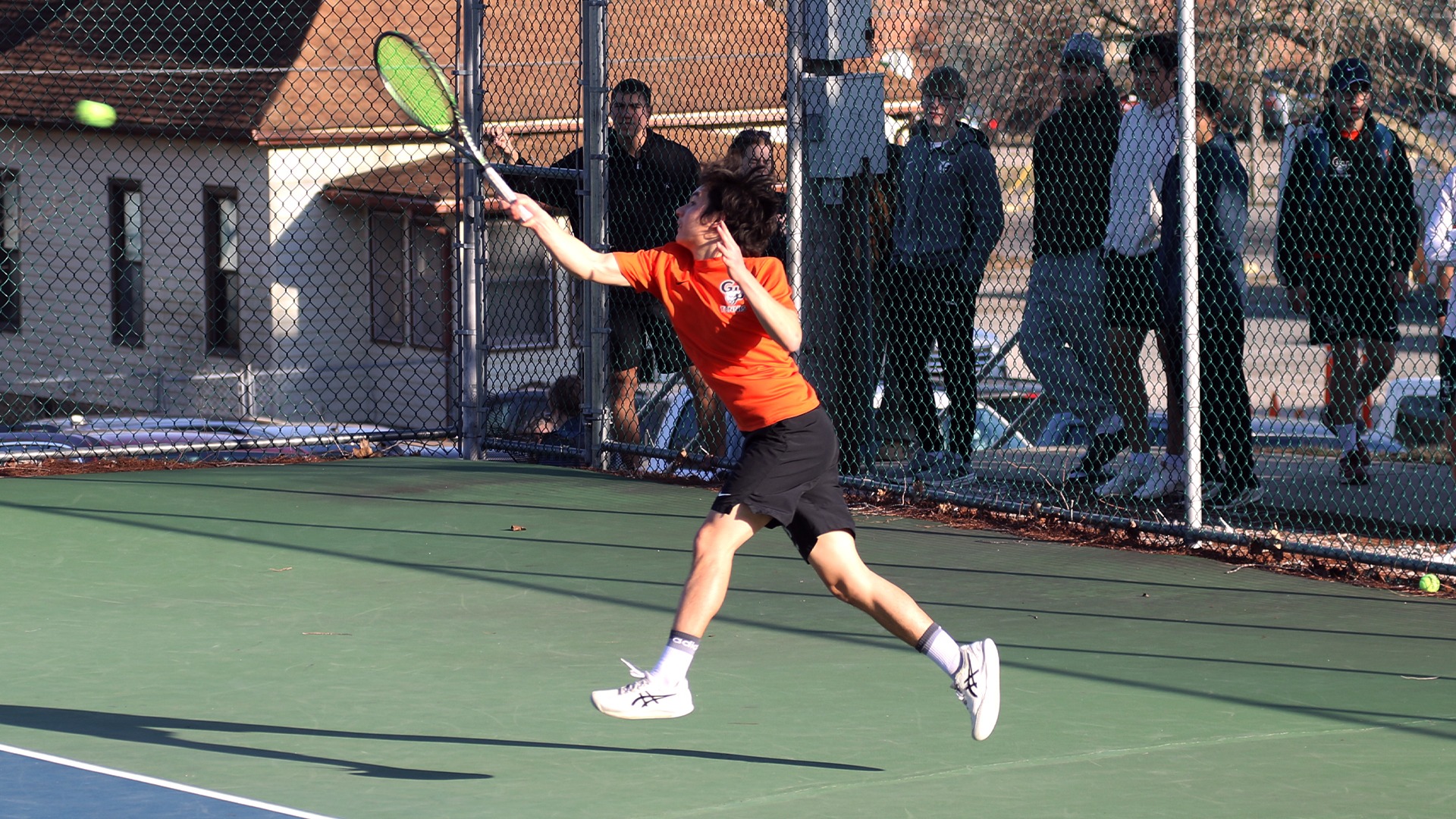 Jade Dynamic in orange shirt hitting ball (overhead) 