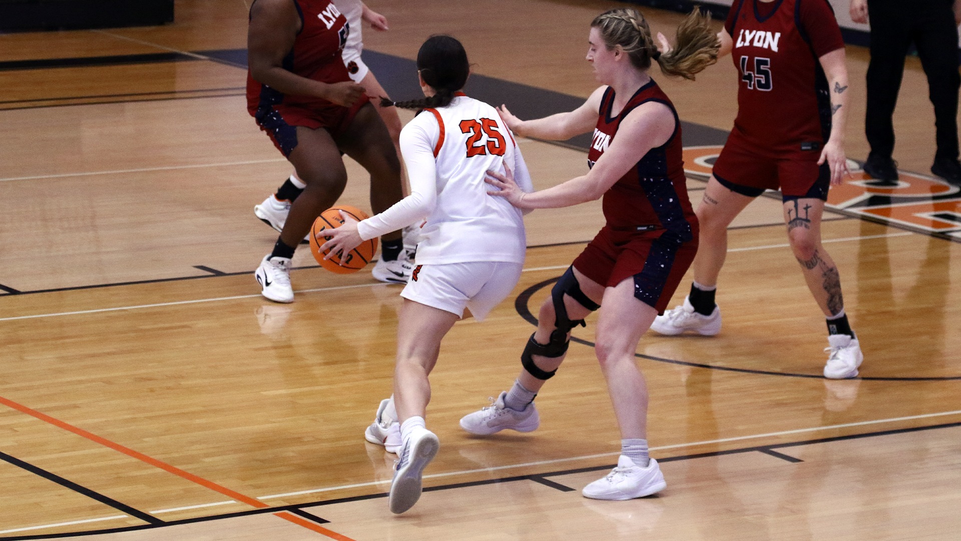 Rylee Hipp in white jersey dribbling around a lyon player