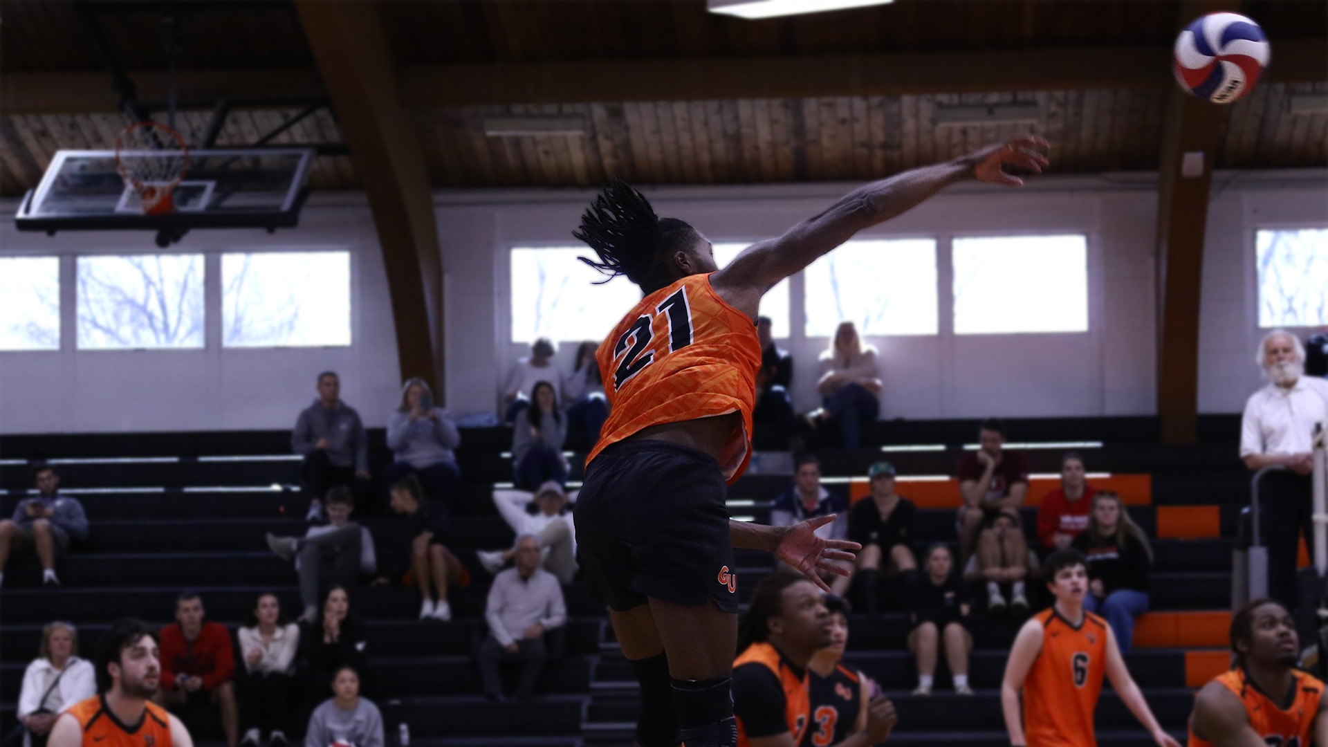 Tyrone Ealy in orange jersey and black shorts attacking ball