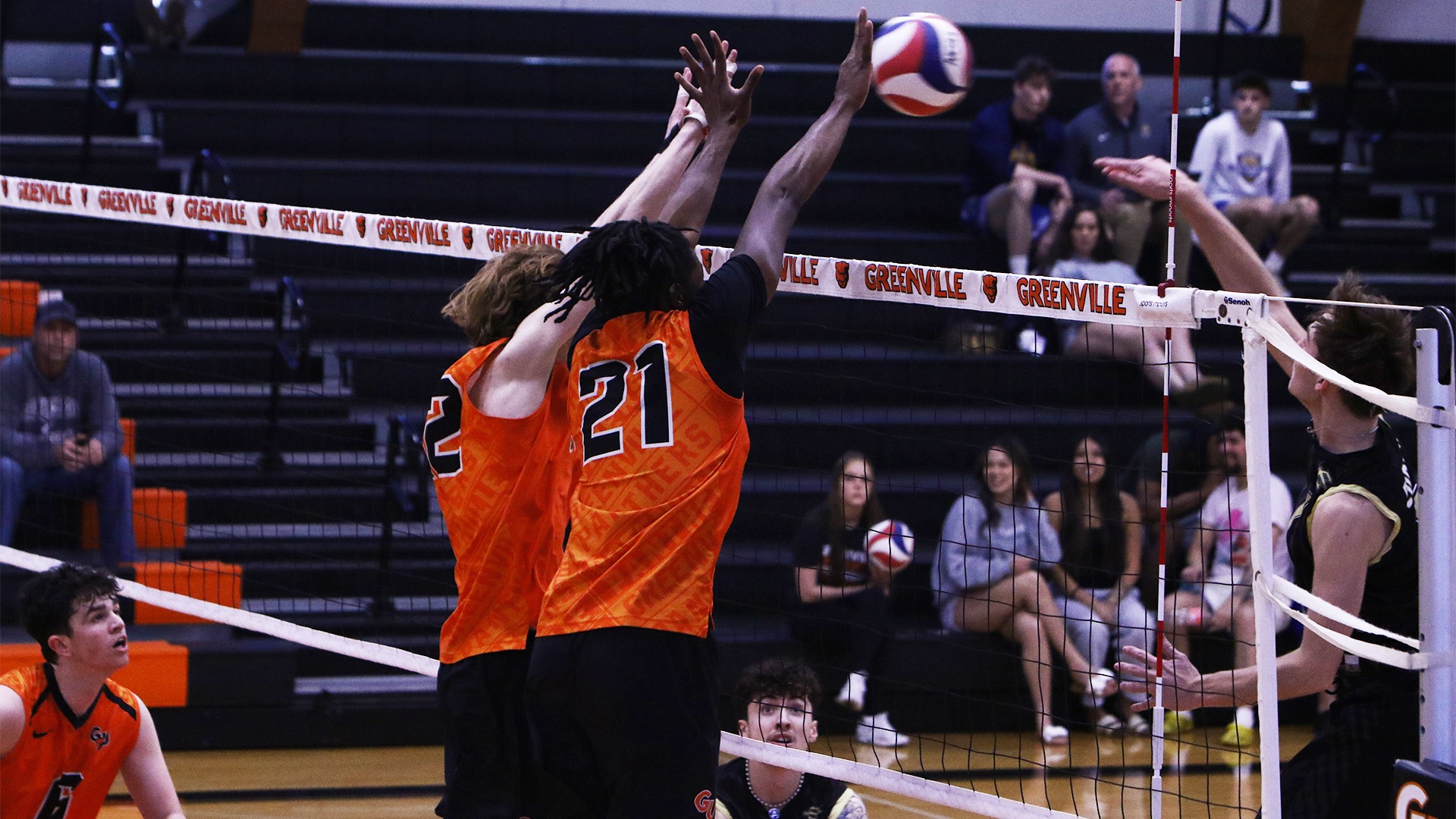 Weir and Ealy in orange jerseys blocking a ball at the net