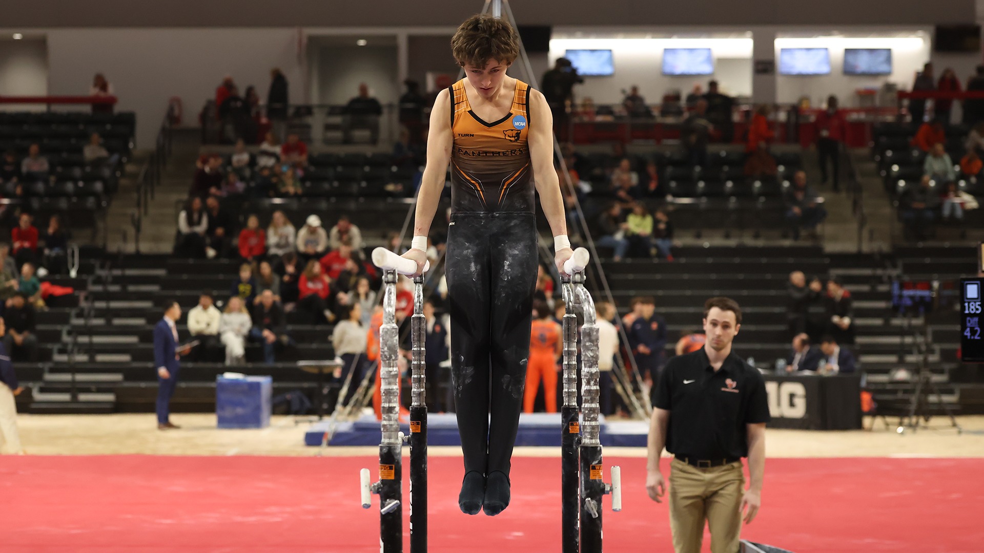 Donovan Diviney in orange uniform on parallel bars