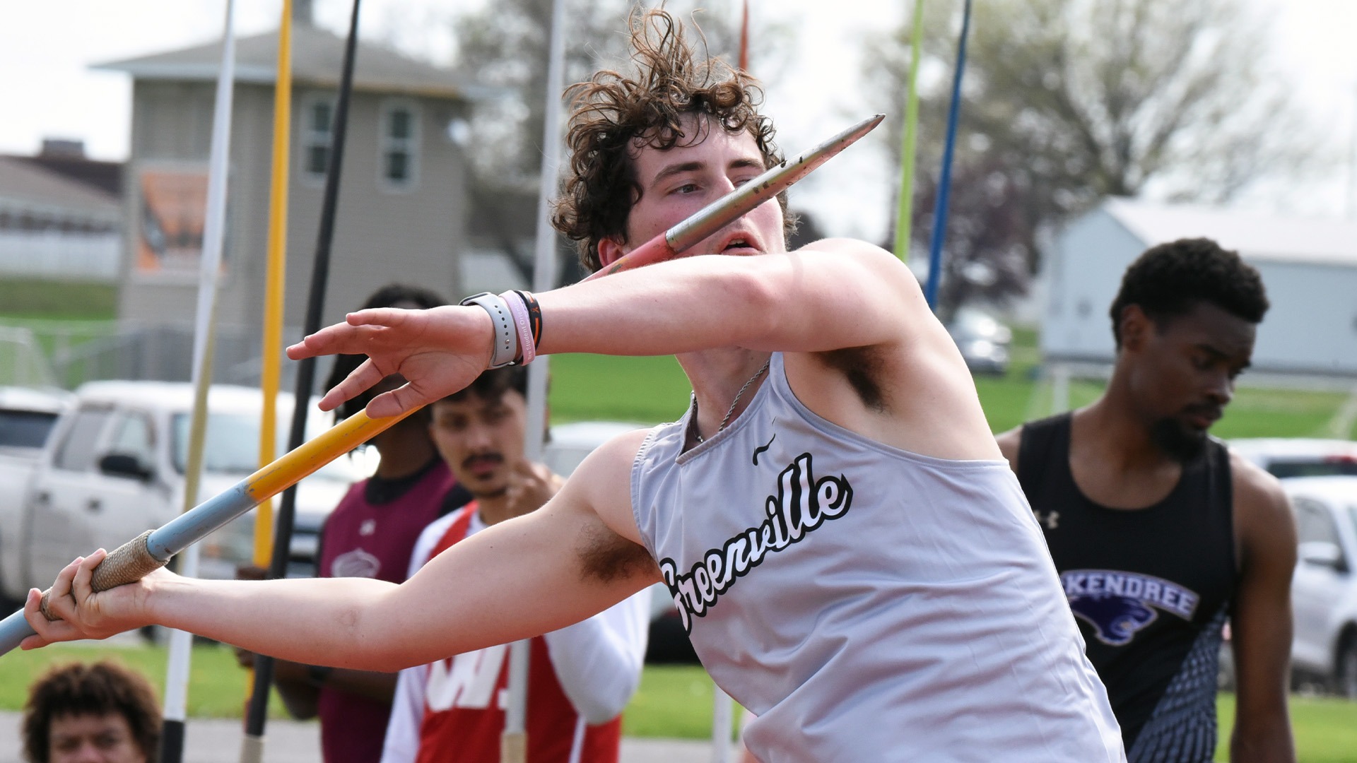Men's javelin thrower in grey jersey launching jav