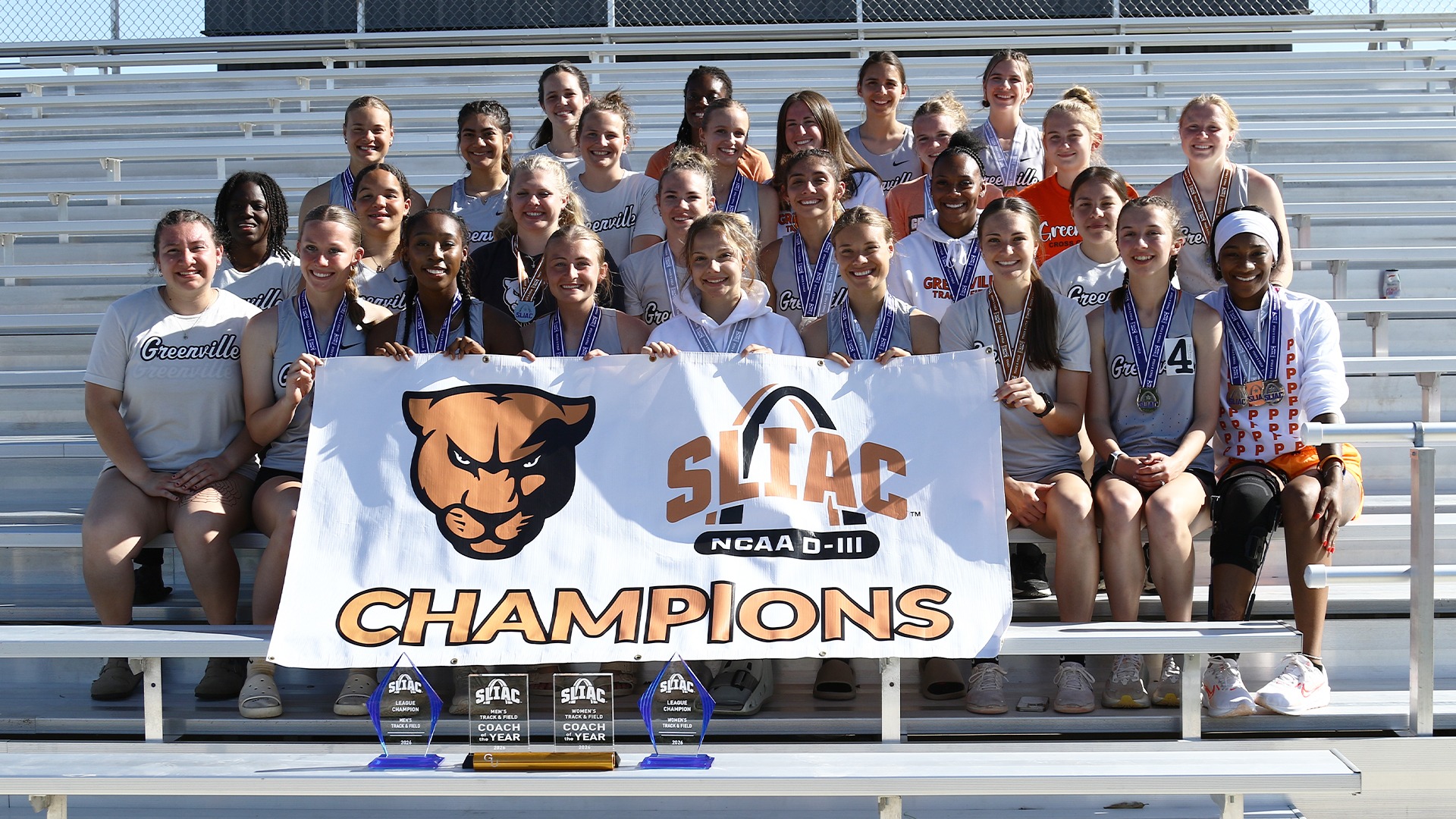 team photo after SLIAC meet holding champ banner and with trophies