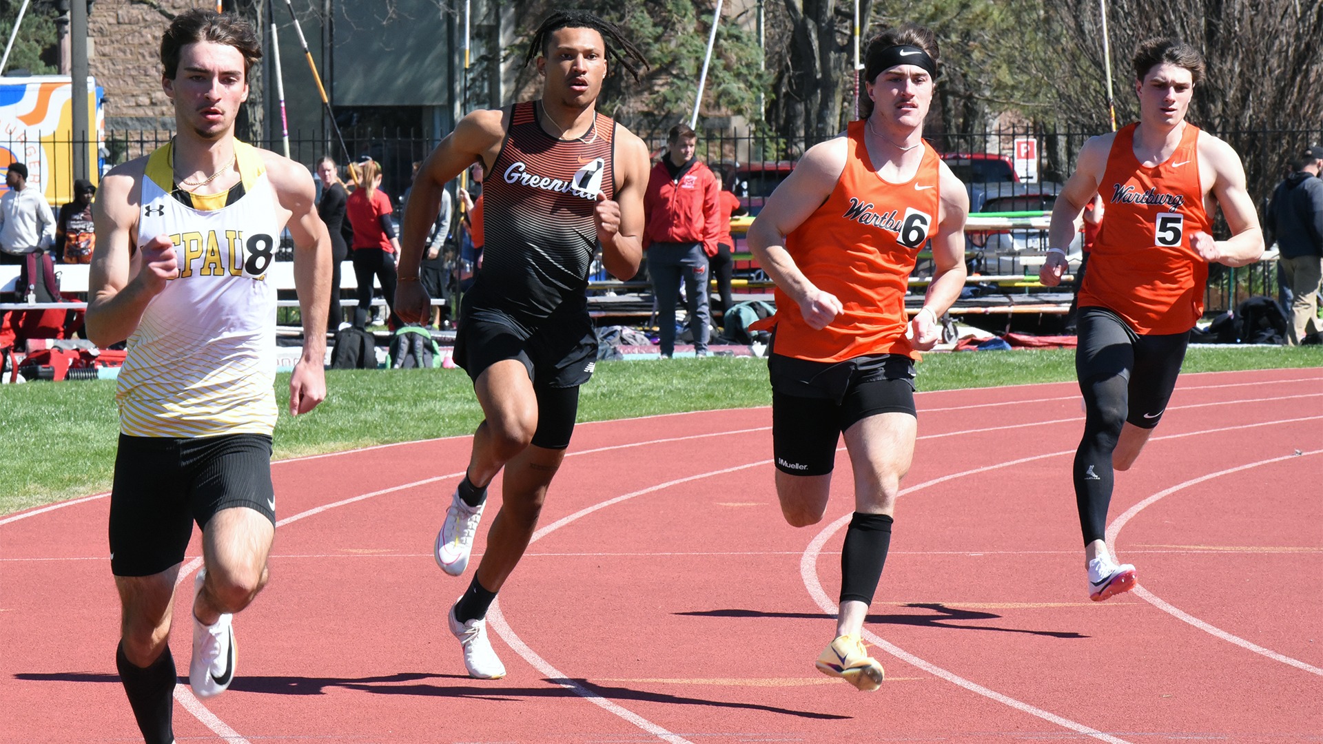 Noel Andino in orange and black uniform running on track against competitors