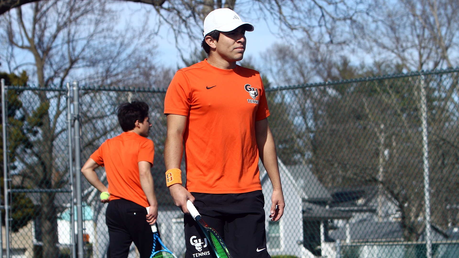 Francisco Trujillo in orange shirt walking on court