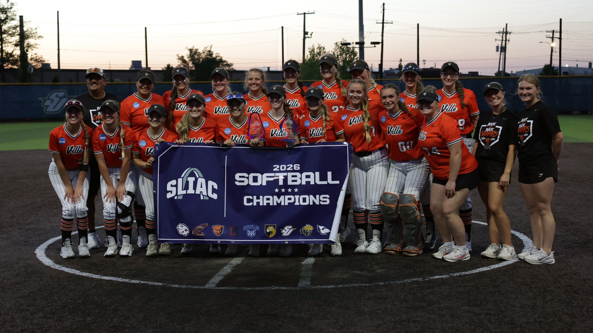 Softball team picture after winning SLIAC Tournament; holding banner and trophies 