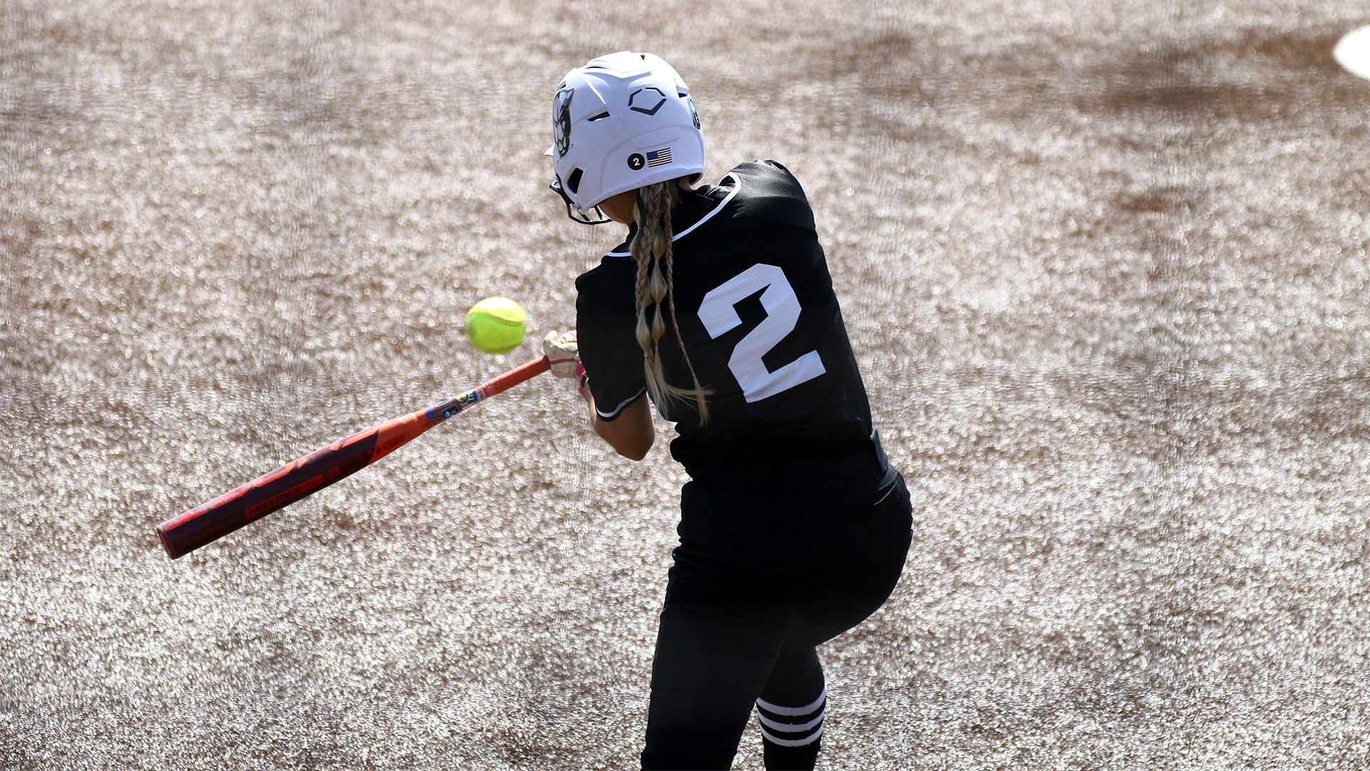 Rylee Bloomer in black jersey hitting ball