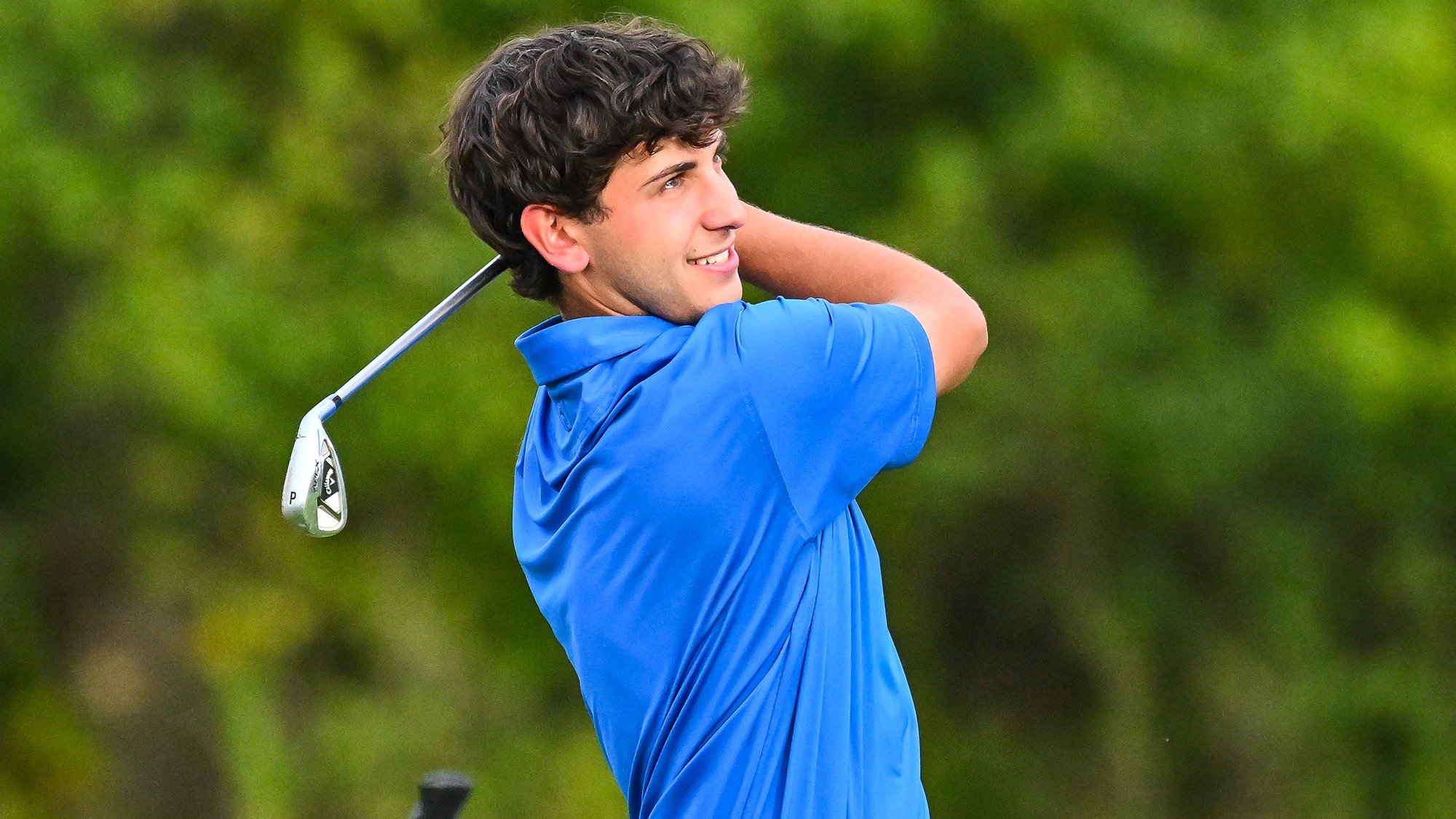 Jake Hendelman watches his shot with a pitching wedge on the practice range in September 2025