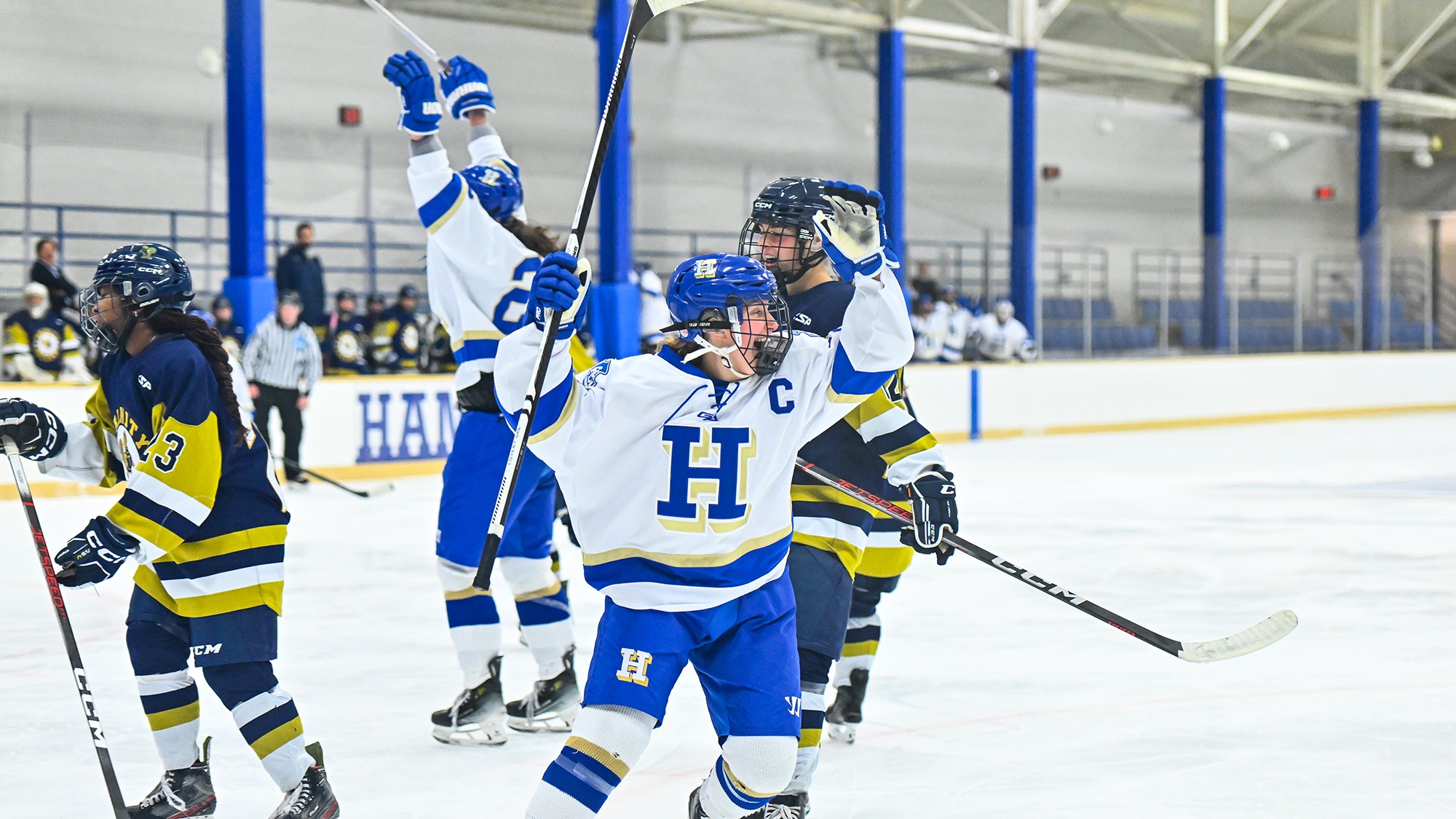Grace Crowley raises her hockey stick and celebrates a goal against Trinity in November 2025
