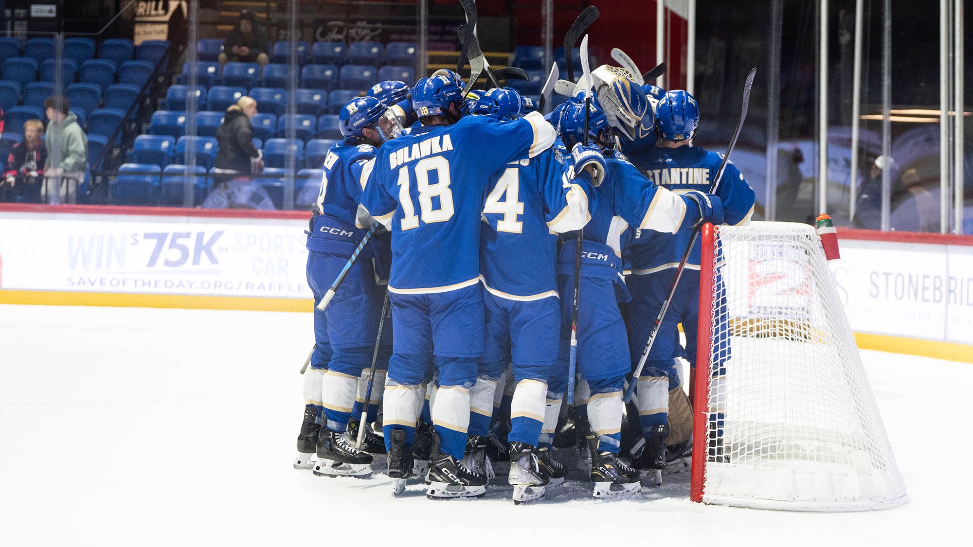 Men's Hockey celebrates winning the Utica Thanksgiving Showcase championship game in November 2025
