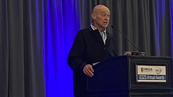 Jon Hind speaks at the podium during the IMLCA Coaches Summit as he accepts his award for a lifetime of service to men's lacrosse