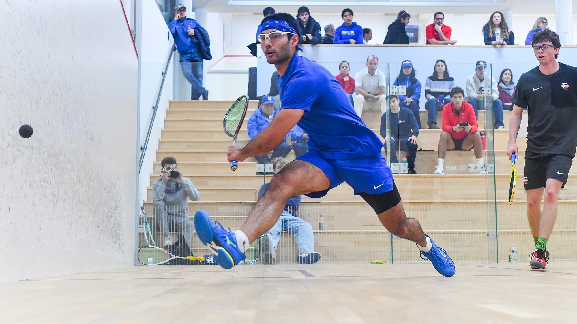 Atreyus Bhavsar lunges for a backhand shot in his squash match against Denison in December 2025