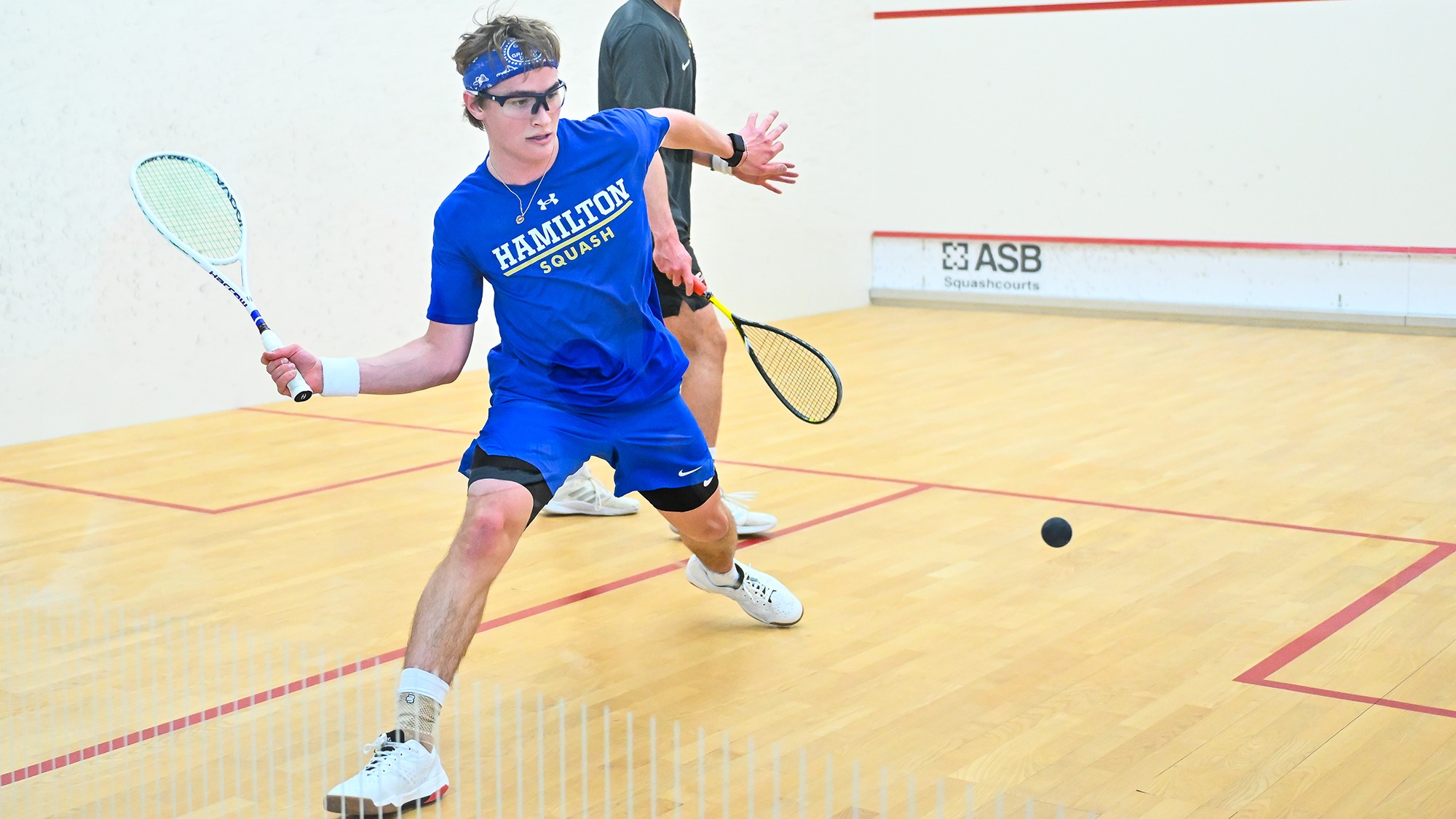 Jamie Merrill reaches back to hit a forehand return in his match against Denison in December 2025