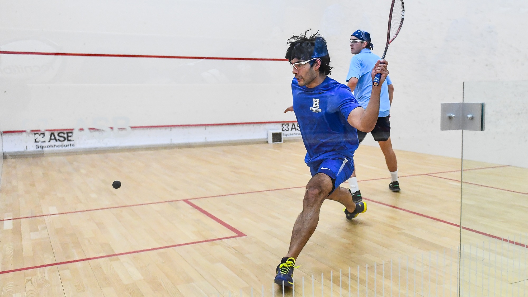 Atreyus Bhavsar hits a forehand return against Connecticut College in January 2025