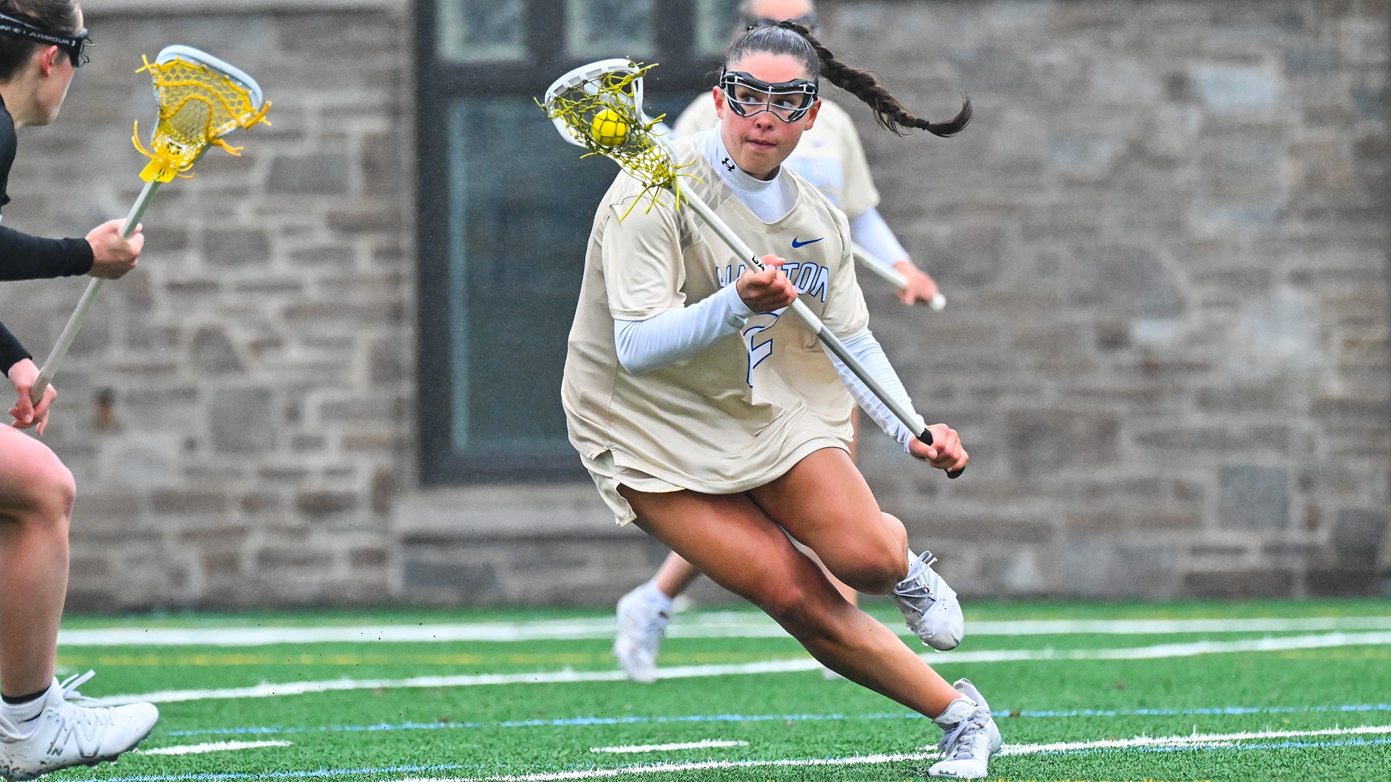 Julia Lee cuts towards the goal with the lacrosse ball in her crosse against Bowdoin in March 2025